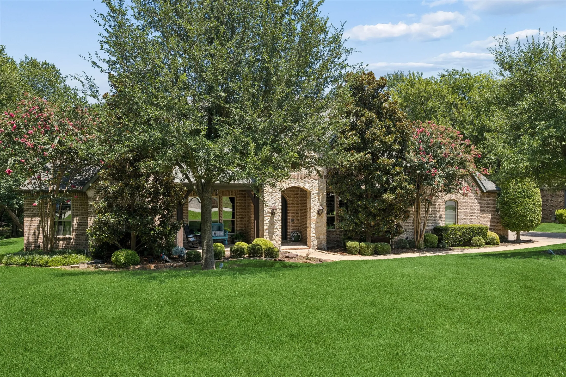 Expansive front lawn with mature trees and established landscaping