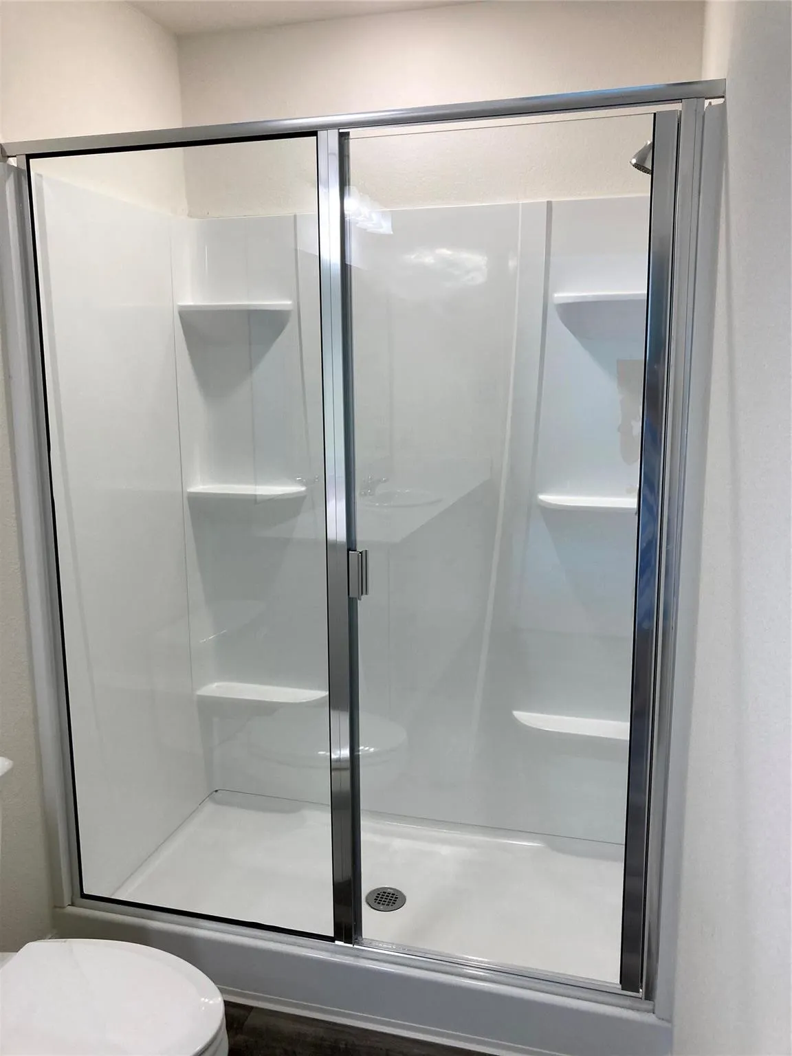 Enclosed shower with clear glass sliding doors and chrome hardware