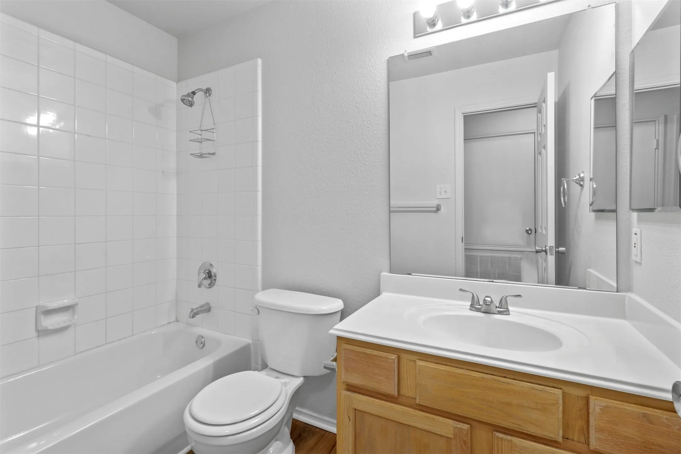 Bathroom featuring a white subway tile shower surround over a tub
