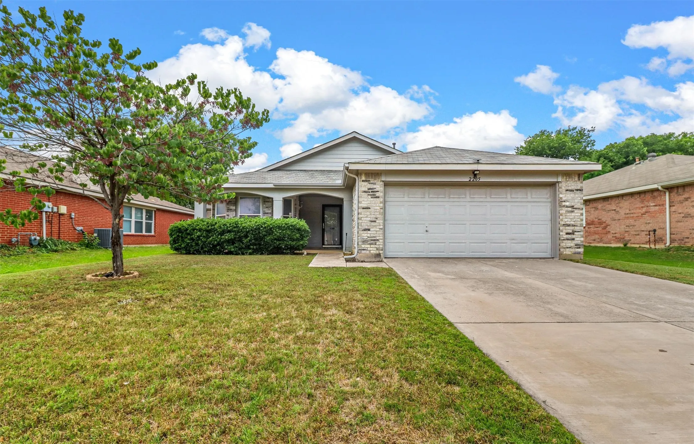 Single-story residence featuring a two-car garage, concrete driveway, and a covered front entry