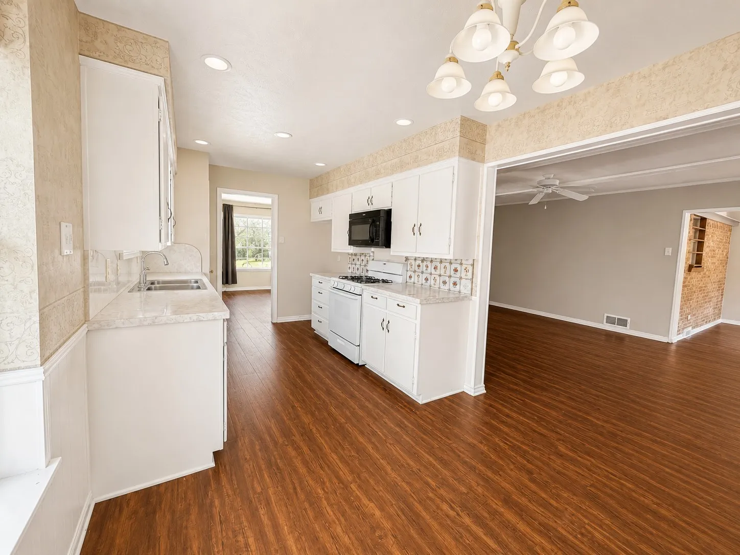 Kitchen featuring white cabinetry, wood-finish flooring, recessed lighting, and an open-concept design to the adjacent living area
