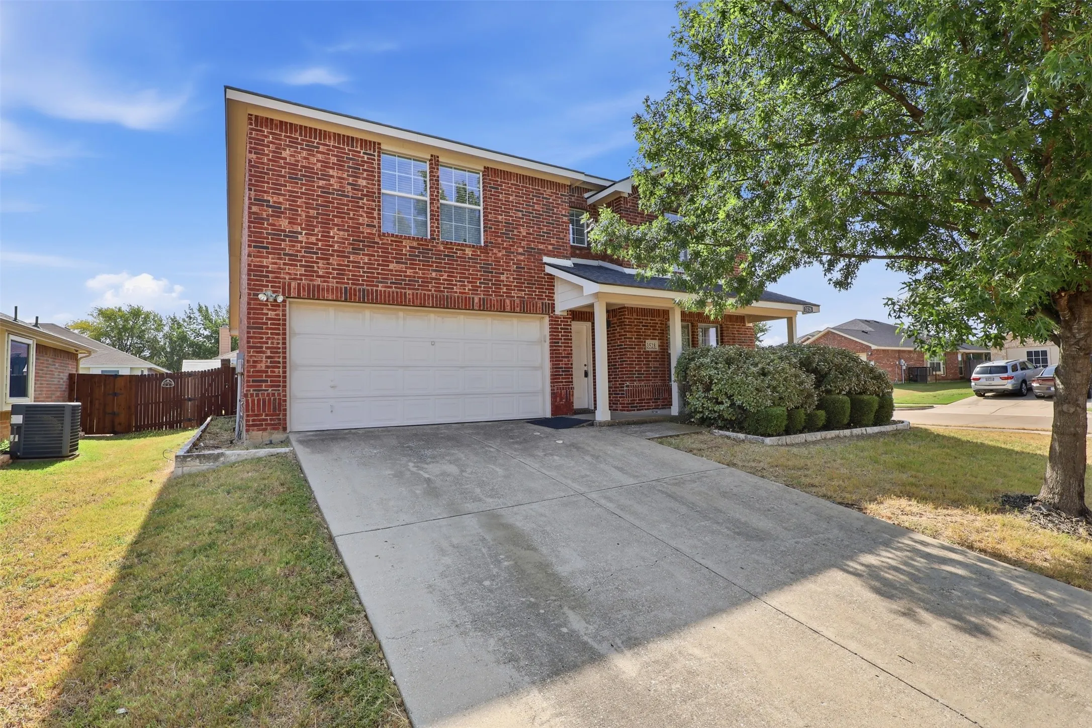 Brick exterior with white garage door and covered entry