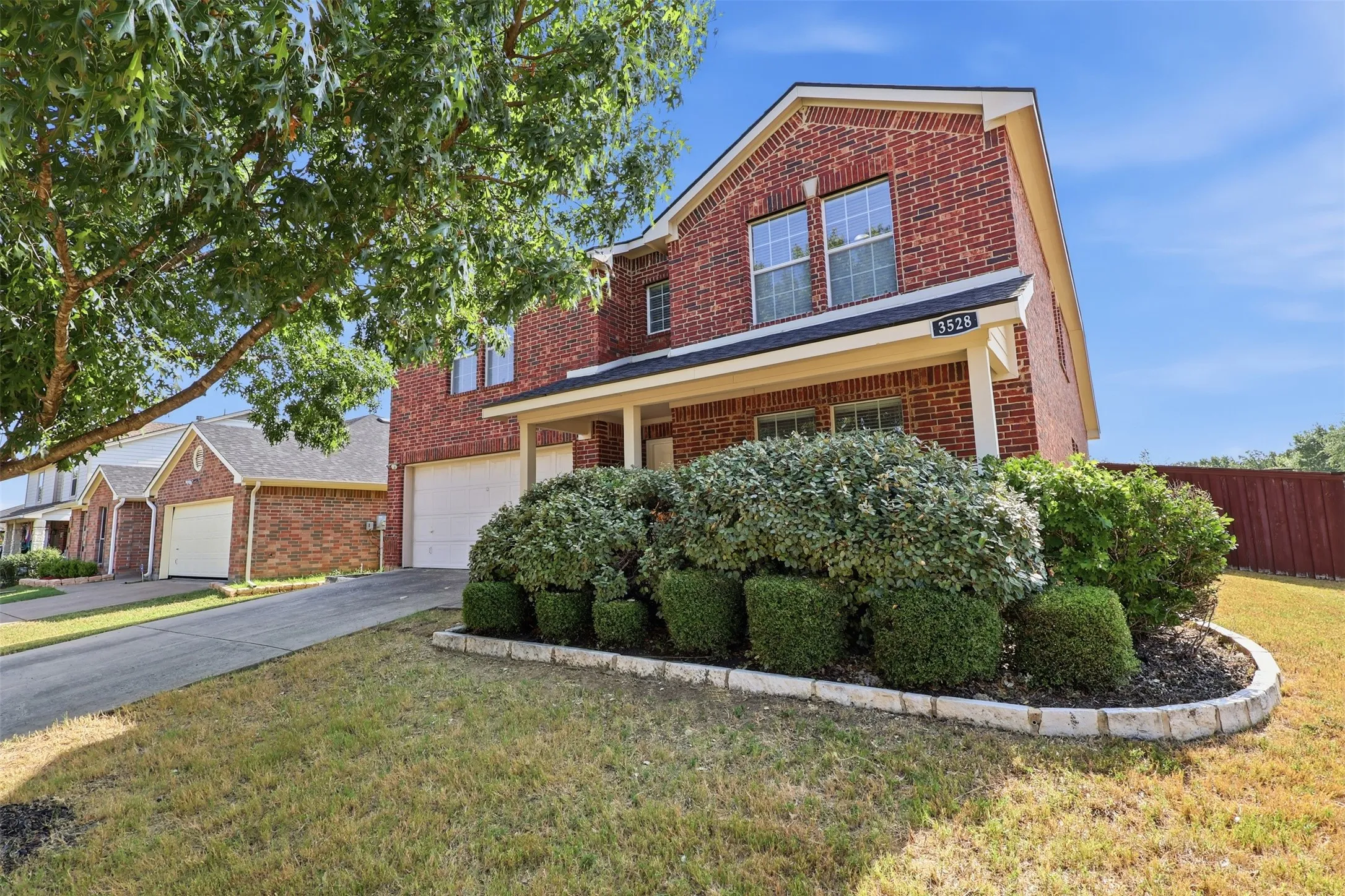 Brick exterior with white trim, featuring a two-car garage