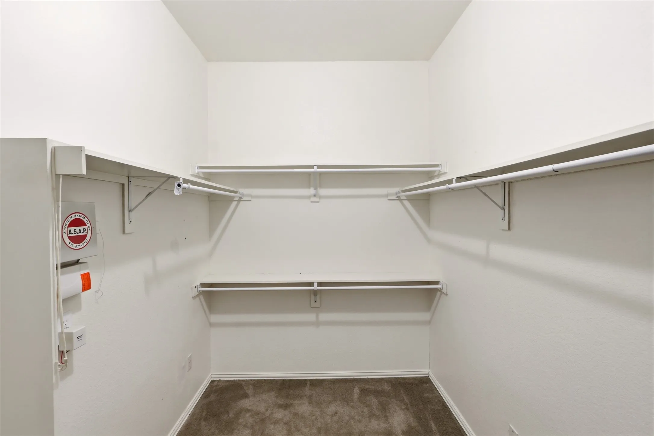Expansive closet featuring white shelving and hanging rods