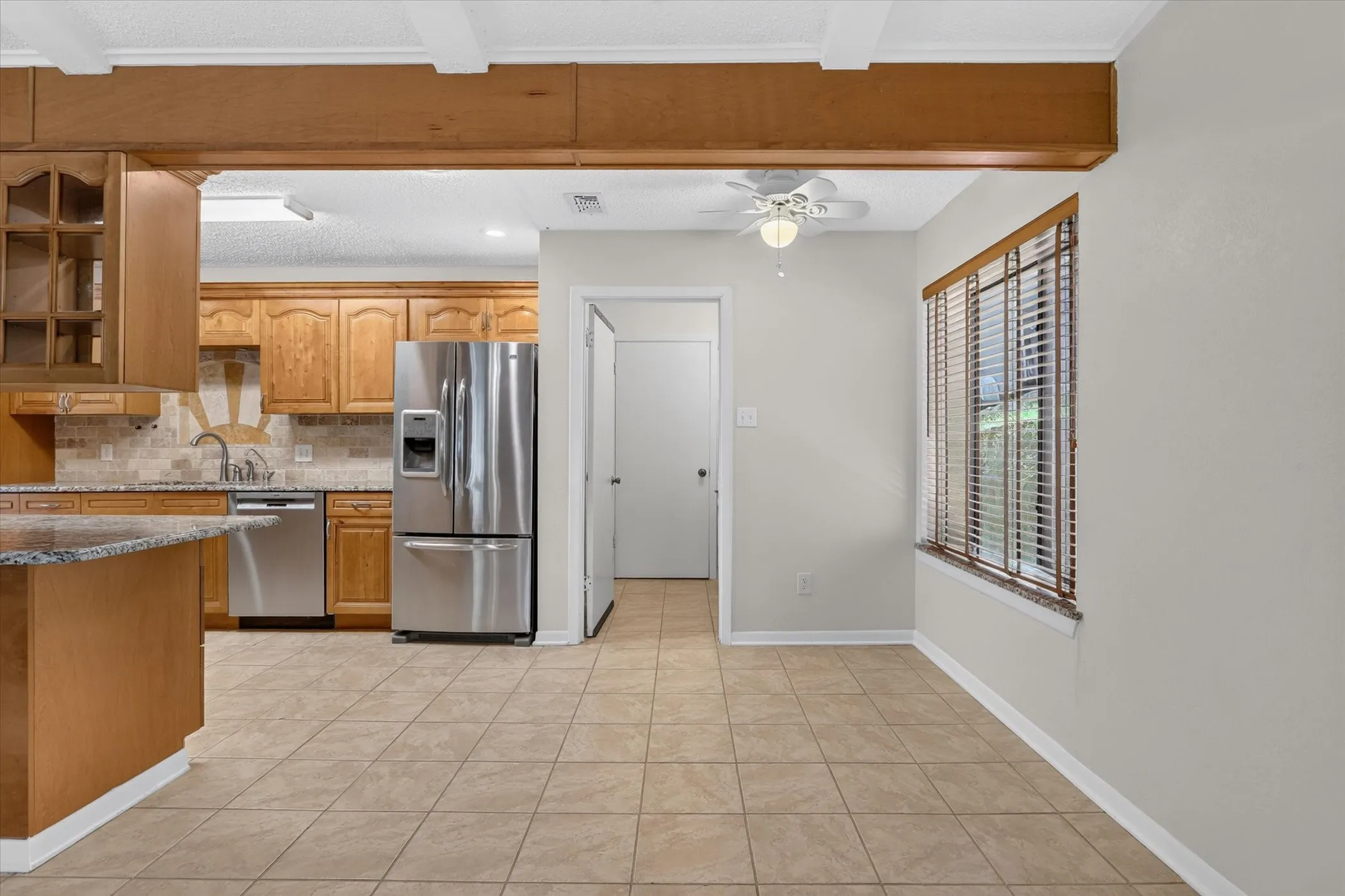 Kitchen featuring wood cabinetry, stainless steel appliances, and a tile backsplash