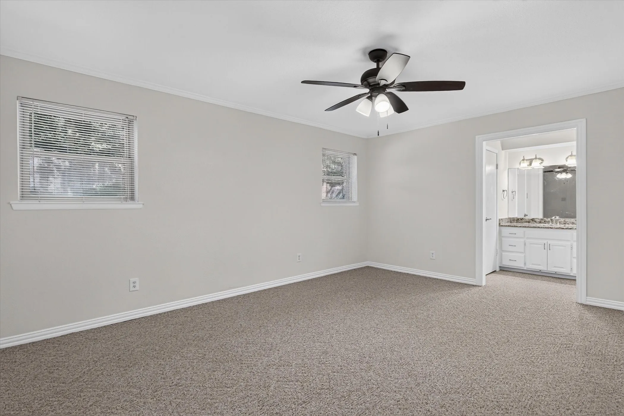 Neutral wall paint, ceiling fan with integrated lighting, carpeted flooring, and a window with blinds