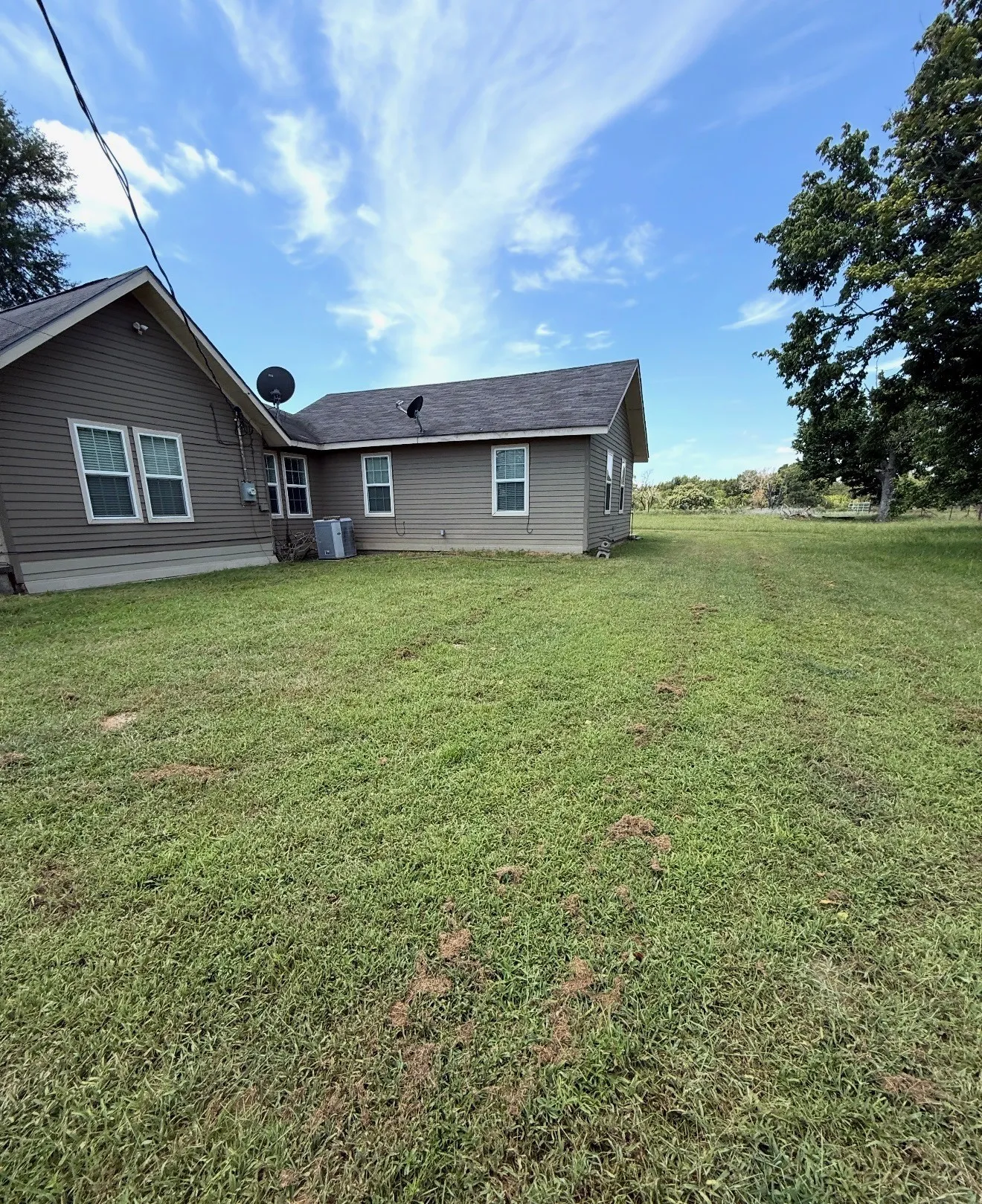Expansive green lawn surrounds the property