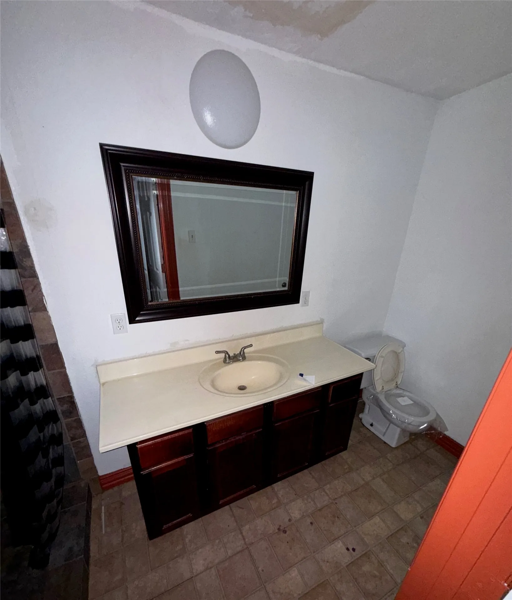 Bathroom featuring a dark wood-finish vanity with an integrated sink and light-toned countertop