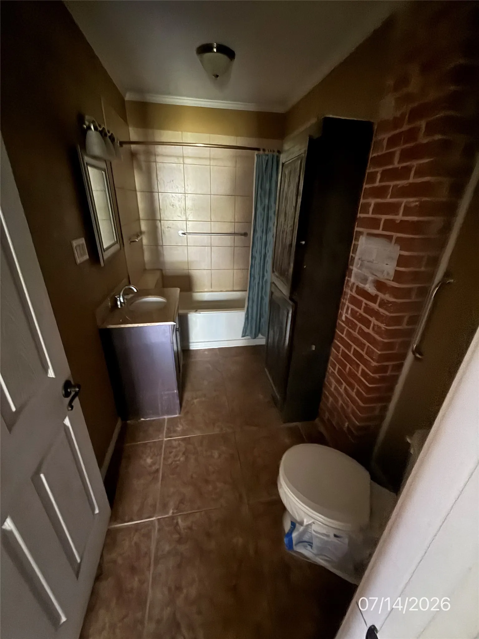 Bathroom featuring ceramic tile flooring, a built-in vanity with sink, and a tiled shower surround