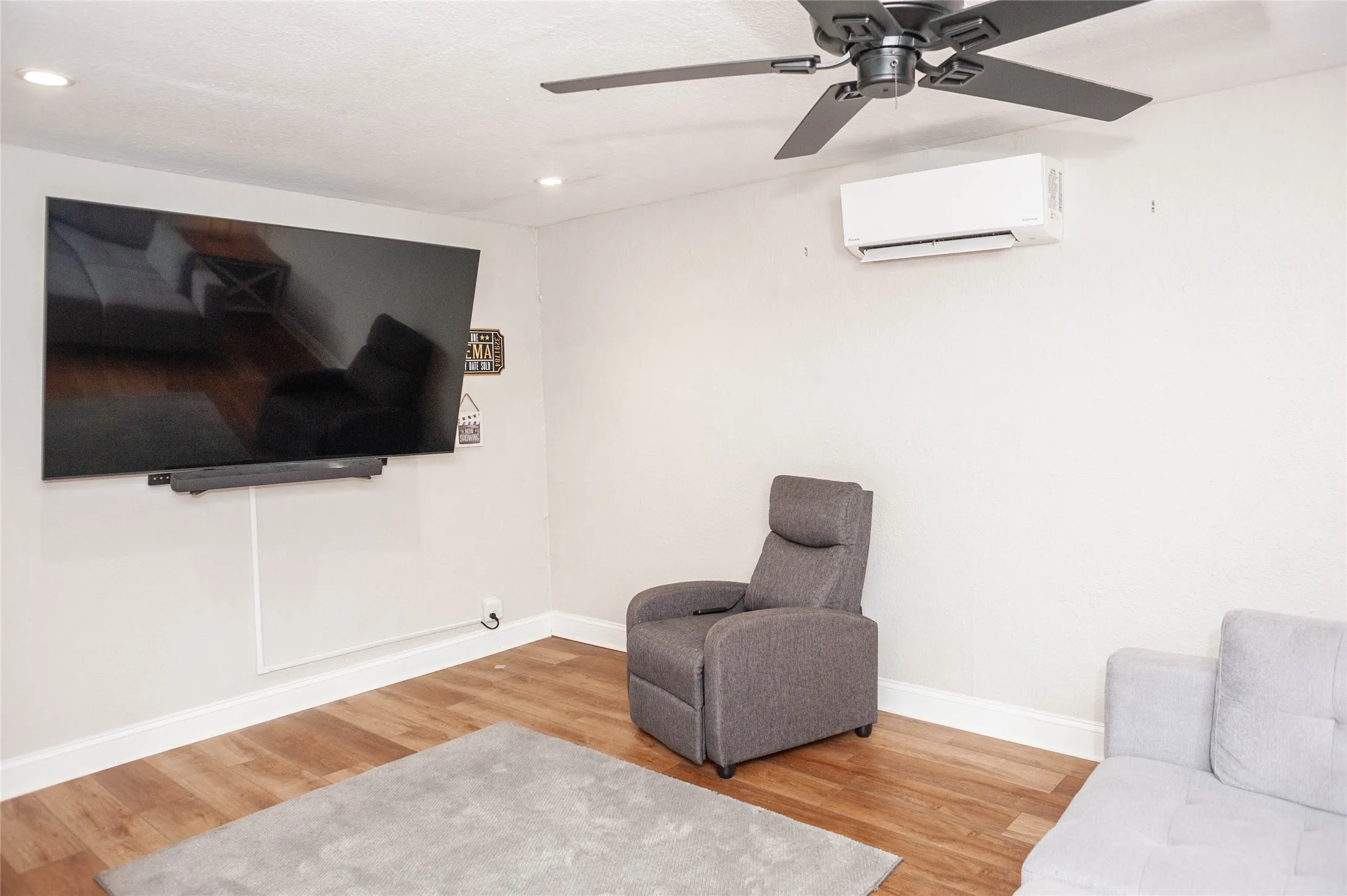 Wood-finish flooring, recessed ceiling lighting, ceiling fan, and wall-mounted climate control unit