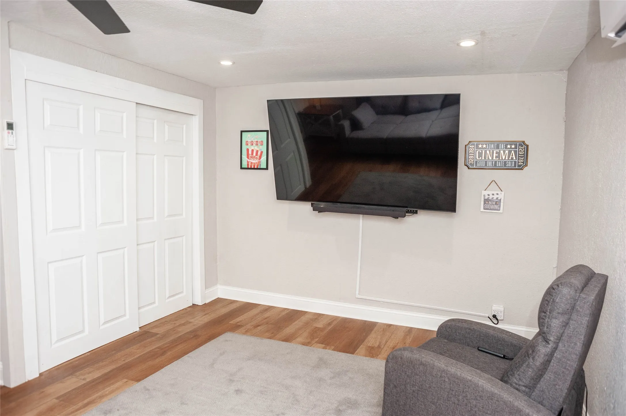 Wood-finish flooring, white bi-fold doors, and recessed ceiling lighting