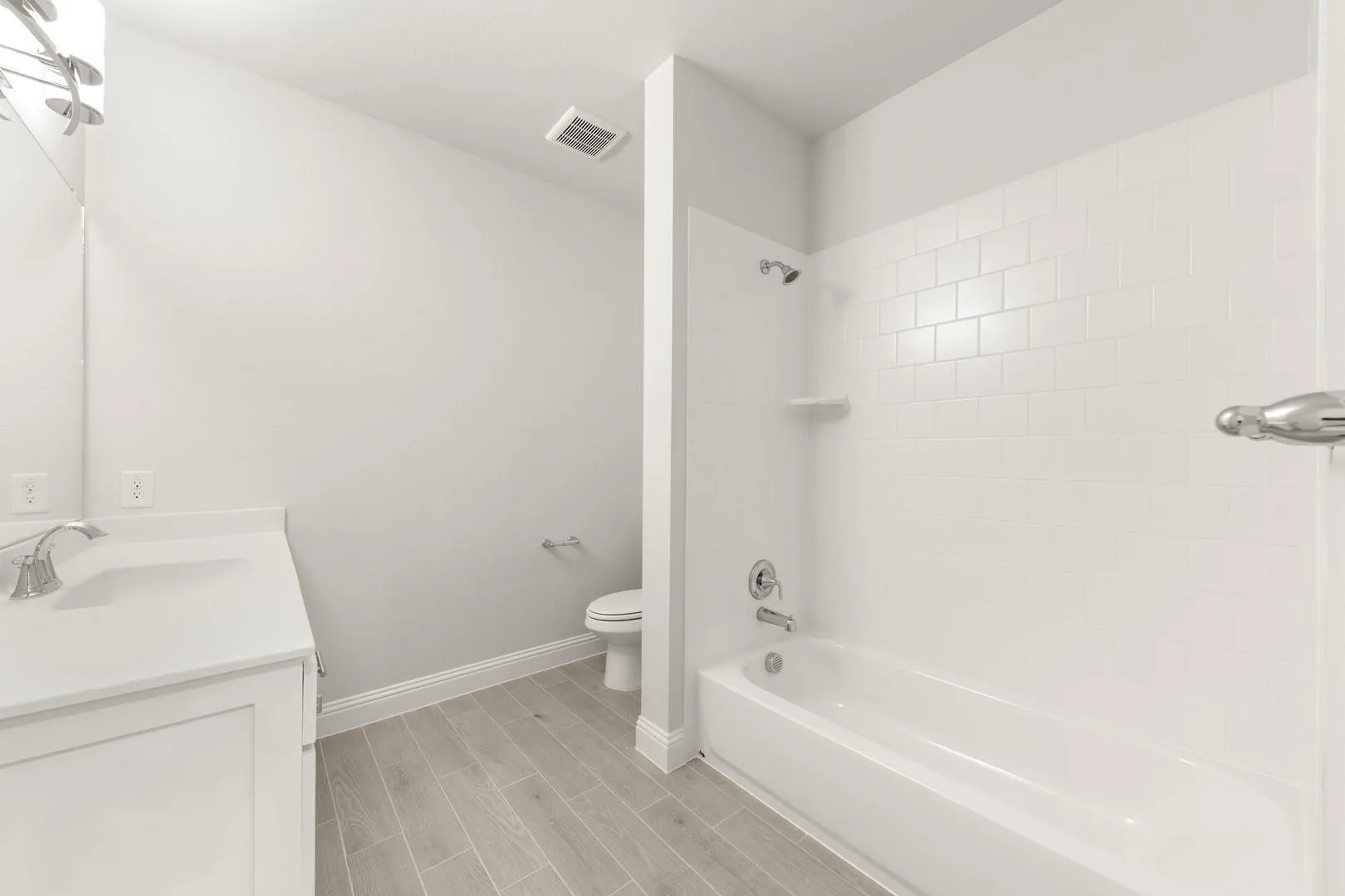Contemporary bathroom featuring a white vanity with integrated sink, chrome faucet, and coordinating light fixture