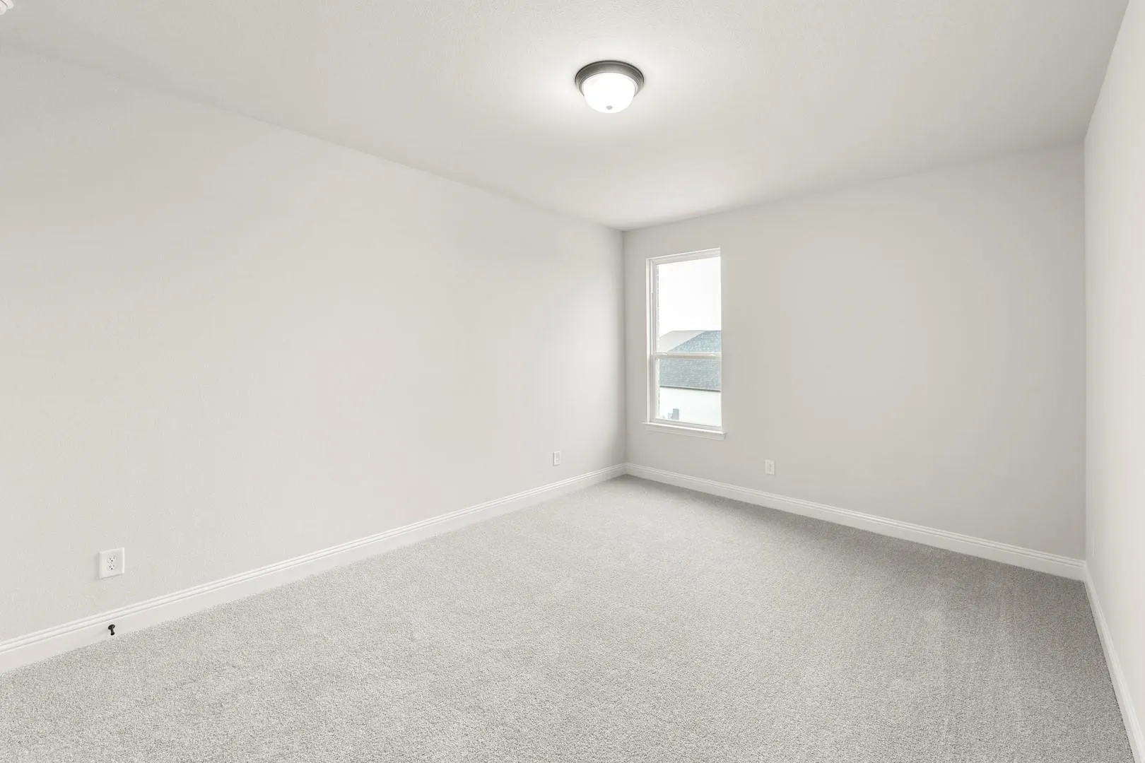 Bright bedroom with neutral carpet flooring, white walls, and recessed ceiling lighting