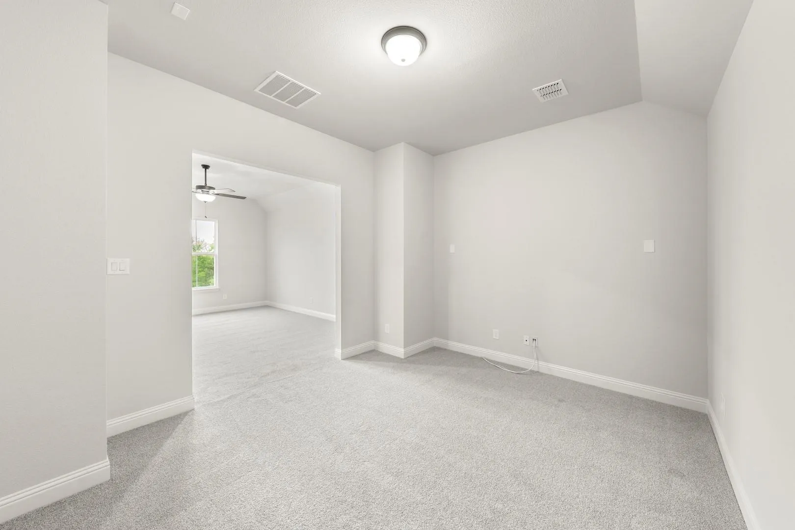 Carpeted room featuring light gray walls, white baseboards, and an overhead light fixture