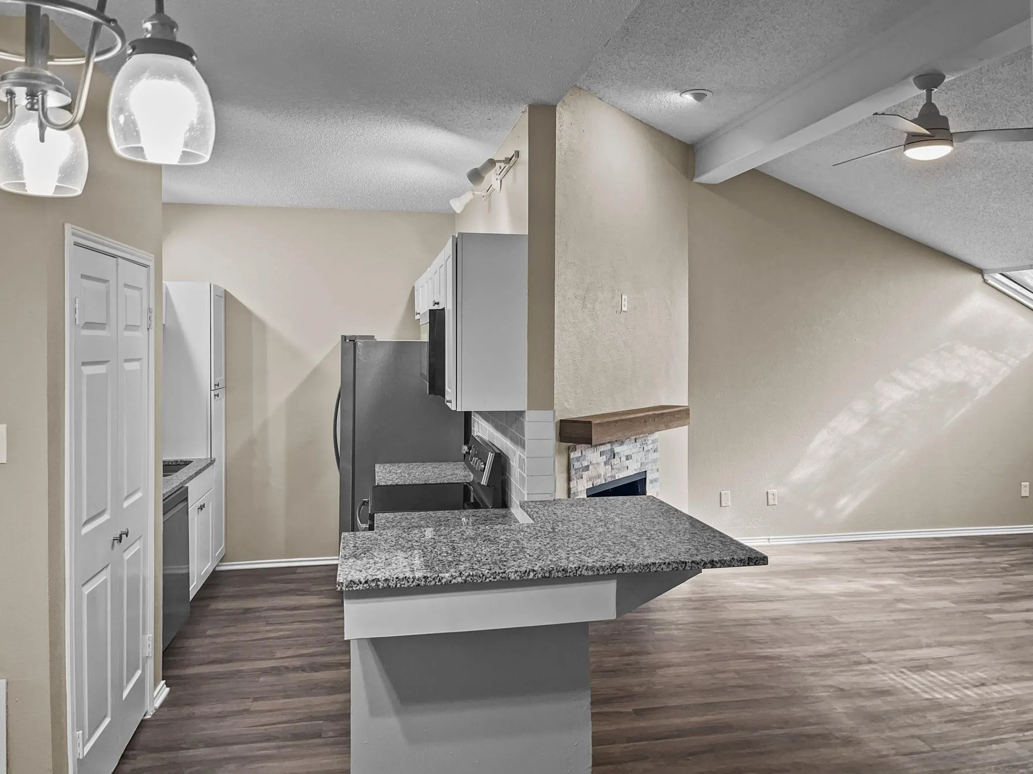 Kitchen featuring granite countertops, white cabinetry, and stainless steel appliances