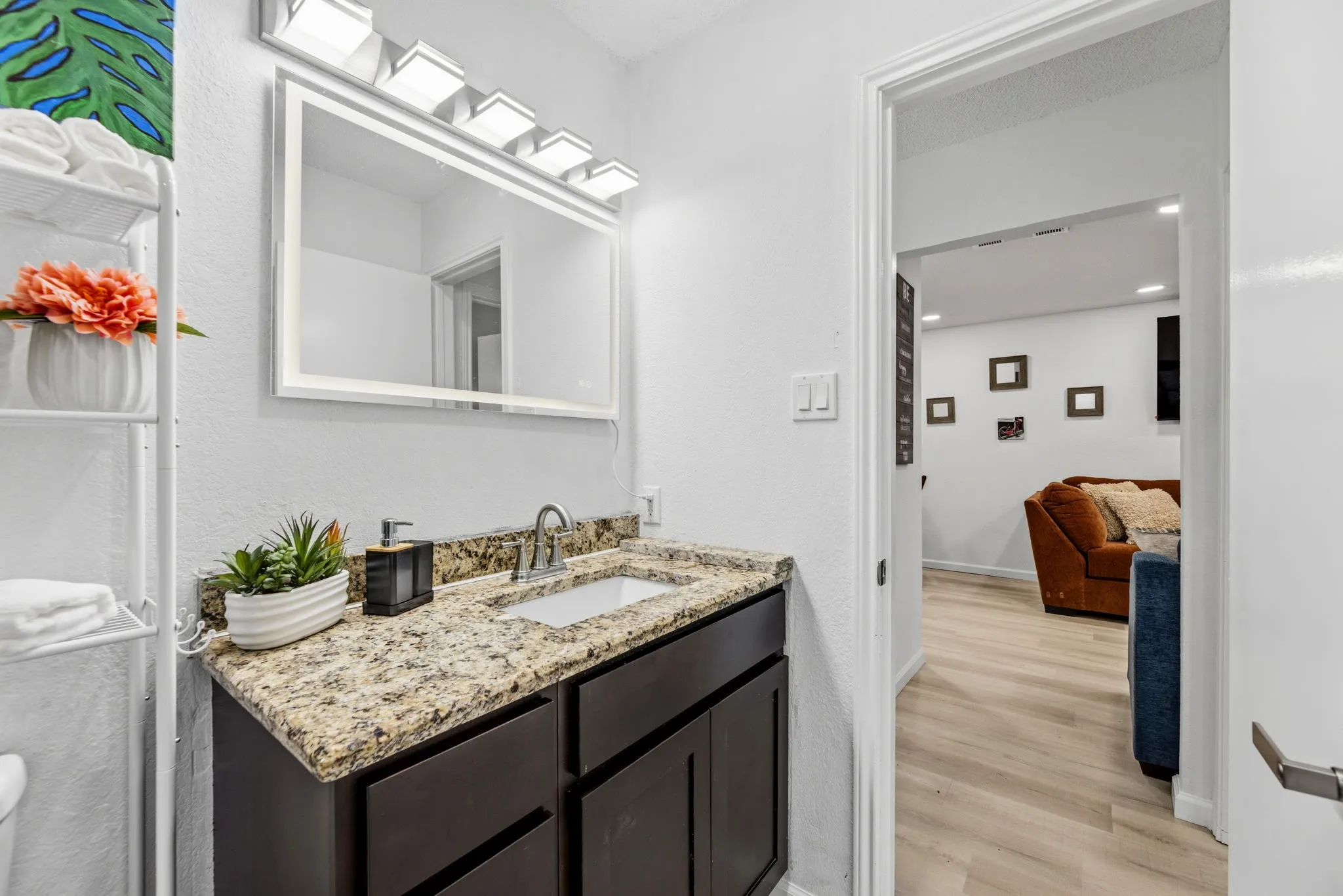 Bathroom vanity featuring a granite countertop, undermount sink, and dark wood cabinetry