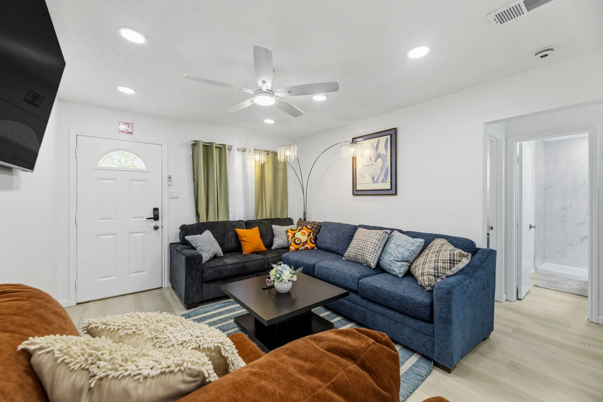 Spacious living area featuring light wood-finish flooring and recessed lighting