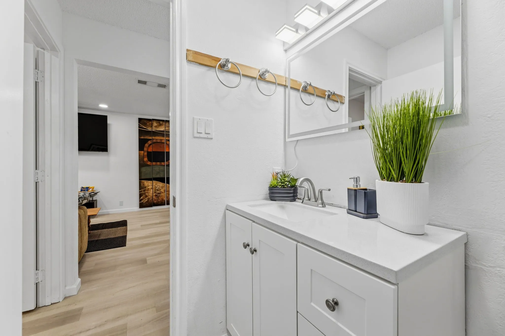 White vanity with a solid surface countertop and undermount sink