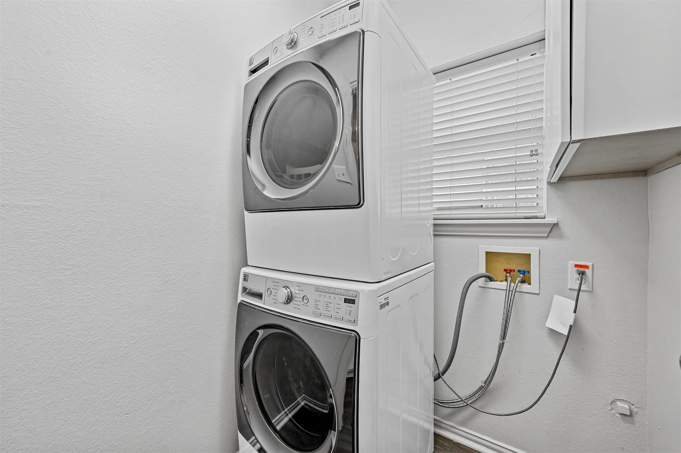 Dedicated laundry area featuring a stacked washer and dryer setup