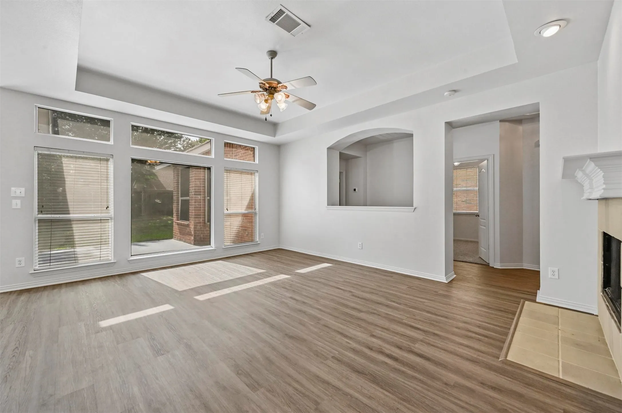 Living area featuring wood-finish flooring, a contemporary ceiling fan, and recessed lighting