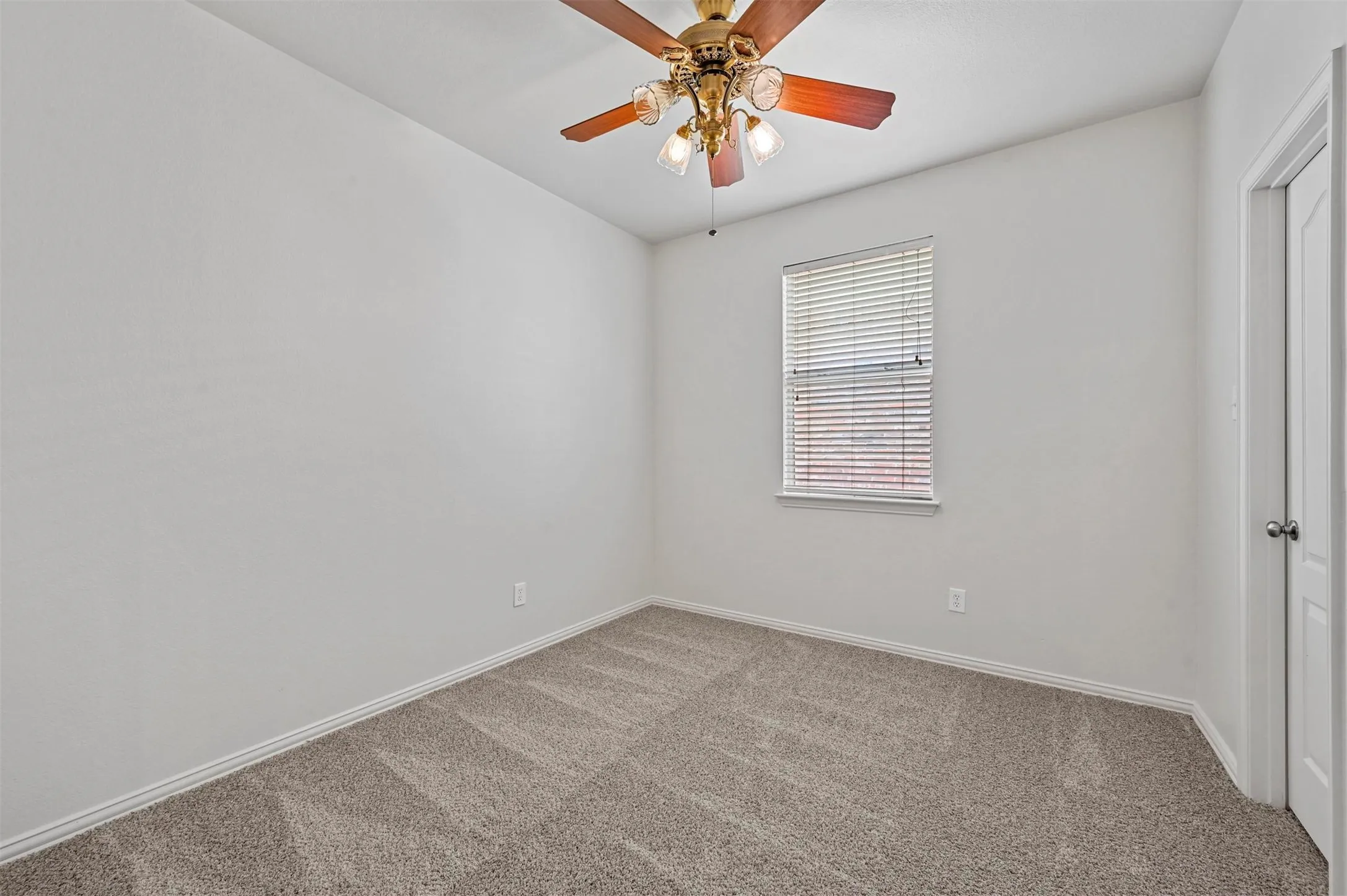 Room featuring neutral-toned carpet flooring, white walls, and a window with horizontal blinds
