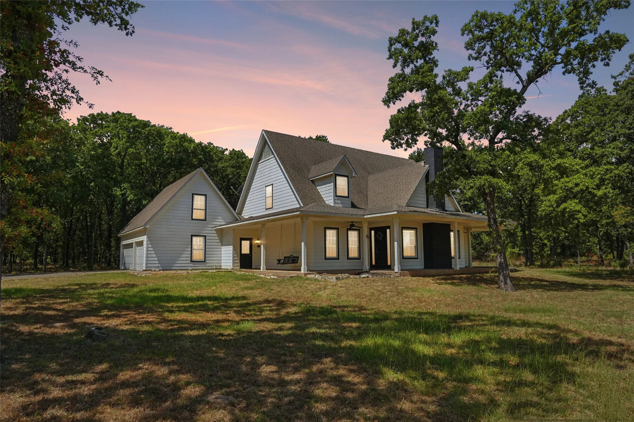 Two-story residence featuring light-colored siding, a covered front porch, and a side-gabled roofline