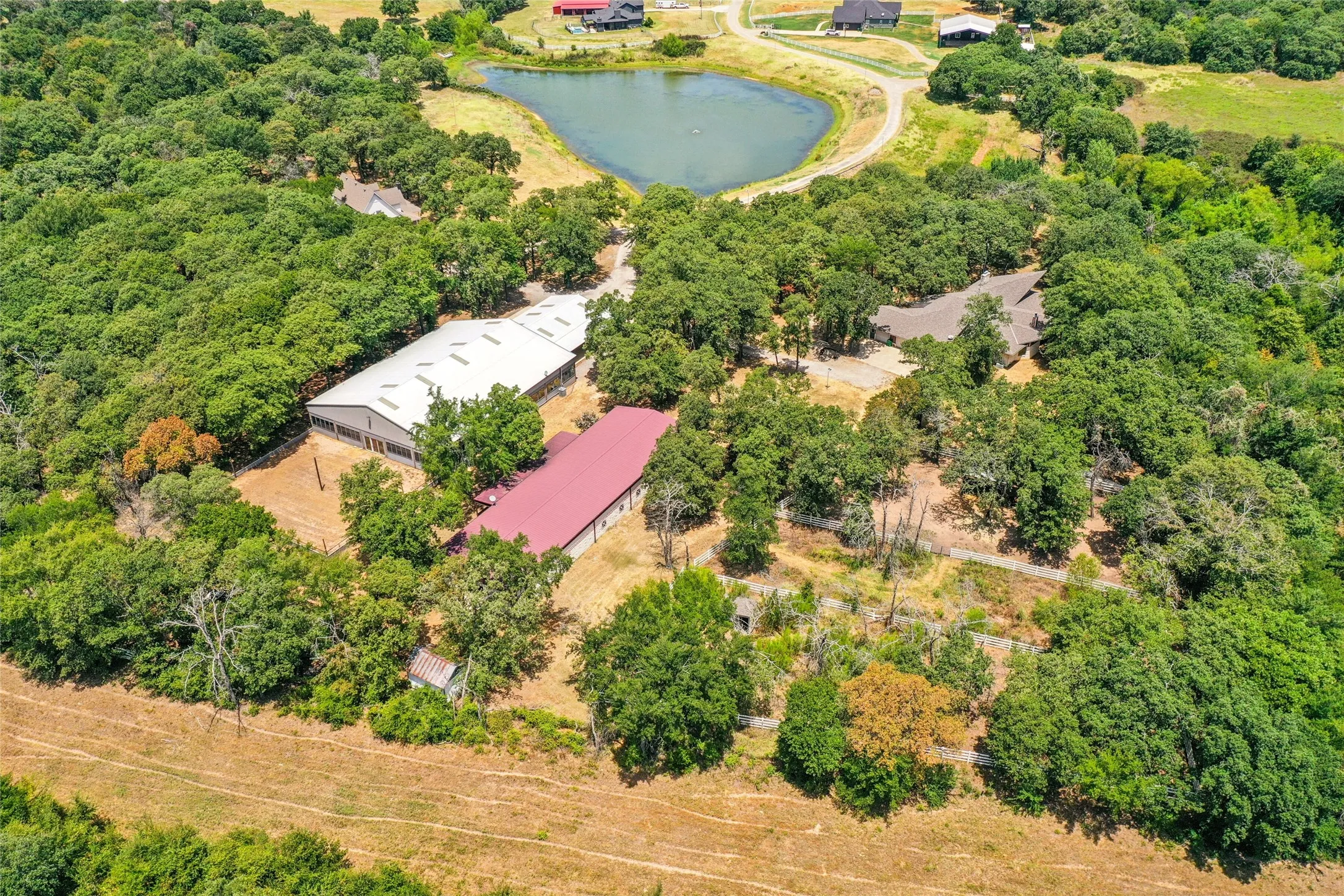 Expansive acreage featuring multiple structures, a private pond, and extensive tree coverage