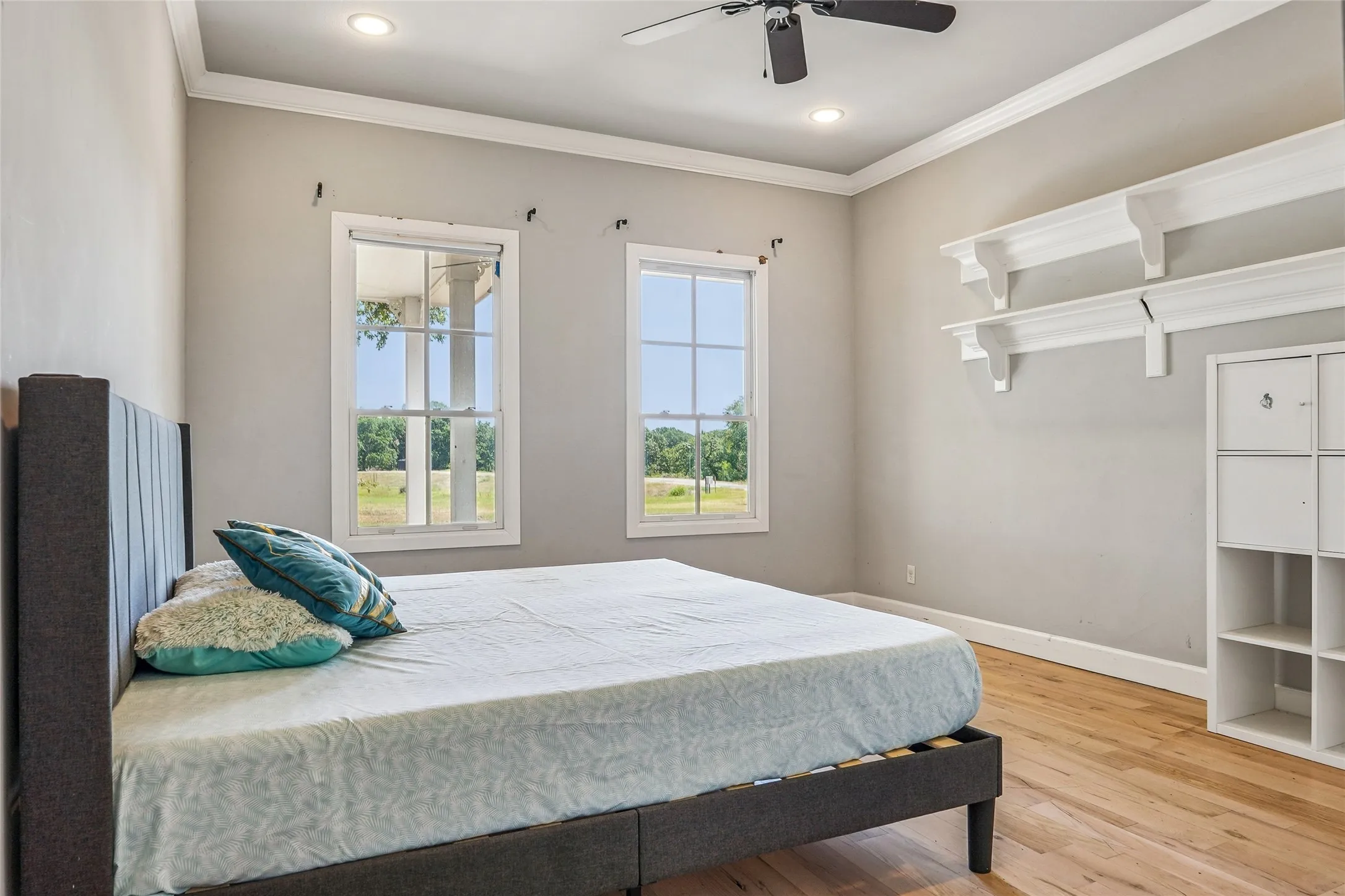 Chamber featuring light wood-finish flooring, recessed lighting, a ceiling fan, and two large windows
