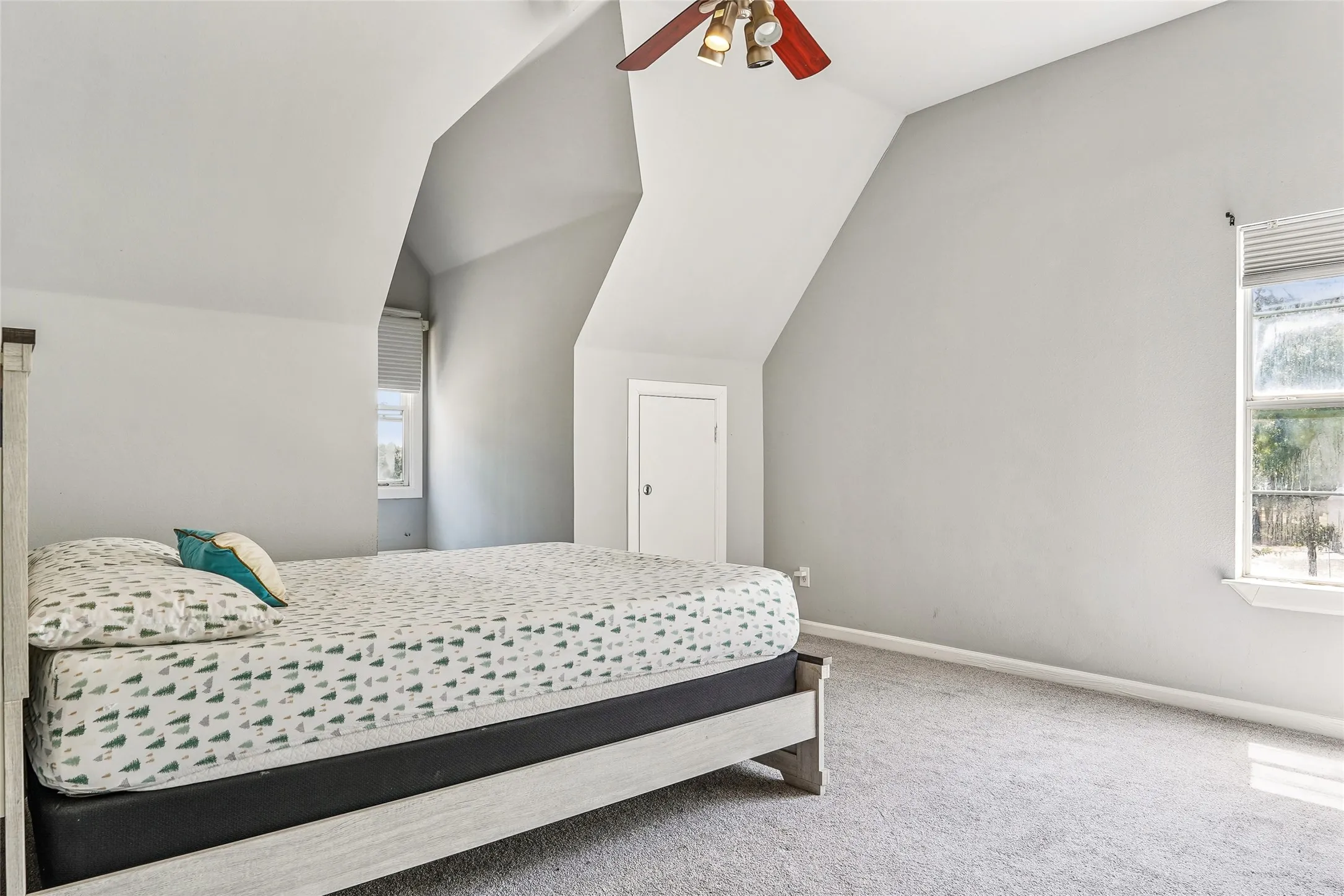Carpeted room with sloped ceilings and light grey walls