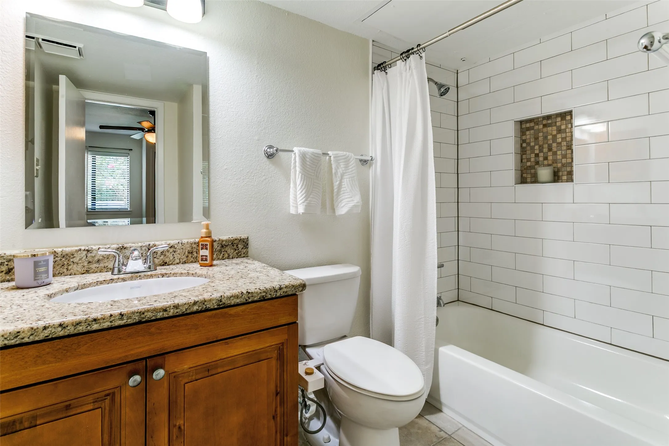 The primary bathroom has been recently remodeled with a new tub, tiled surround, vanity and mirro.