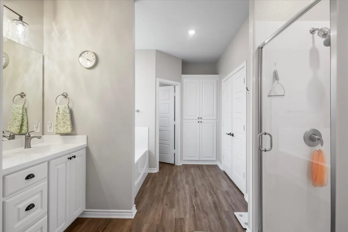  Walk-in glass-enclosed shower with built-in shelving, plus a separate linen closet.