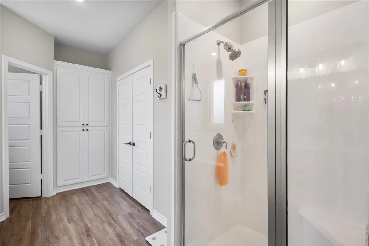  Walk-in glass-enclosed shower with built-in shelving, plus a separate linen​​‌​​​​‌​​‌‌​‌‌​​​‌‌​‌​‌​‌​​​‌​​ closet.