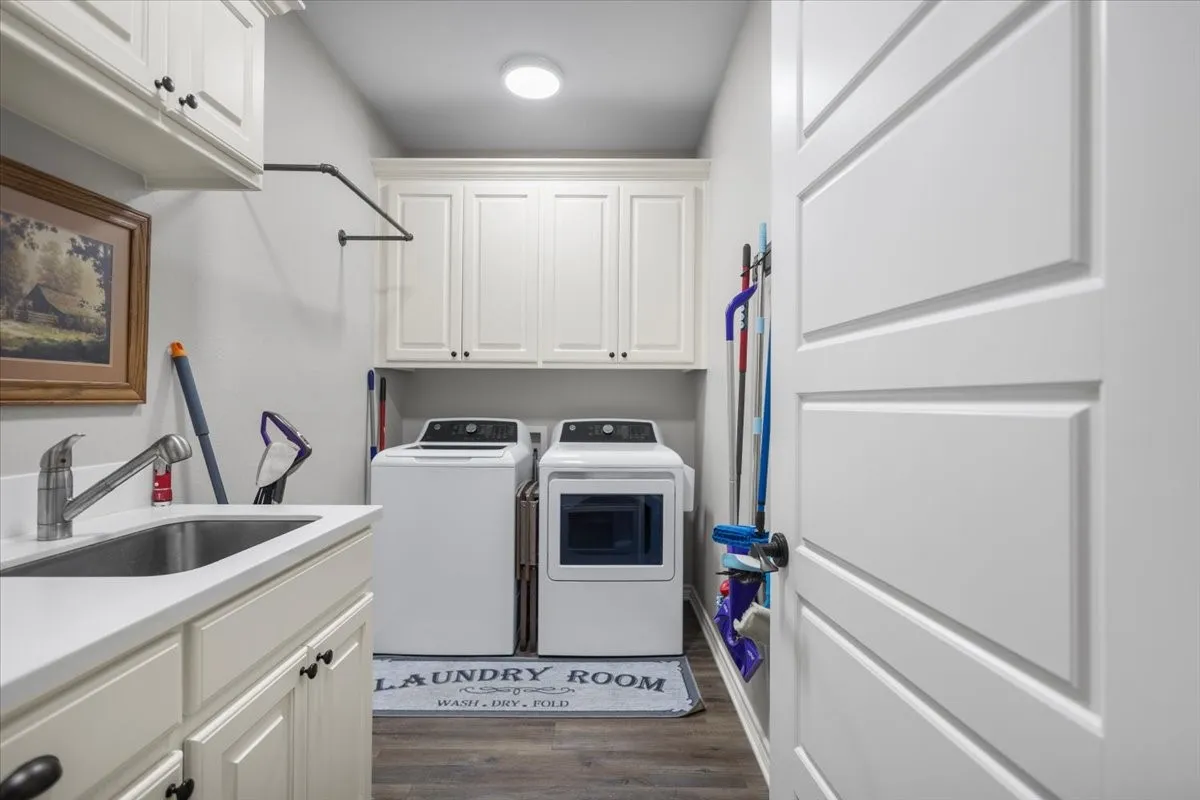 Laundry room with white cabinetry, utility sink, and full-size washer and dryer hookup