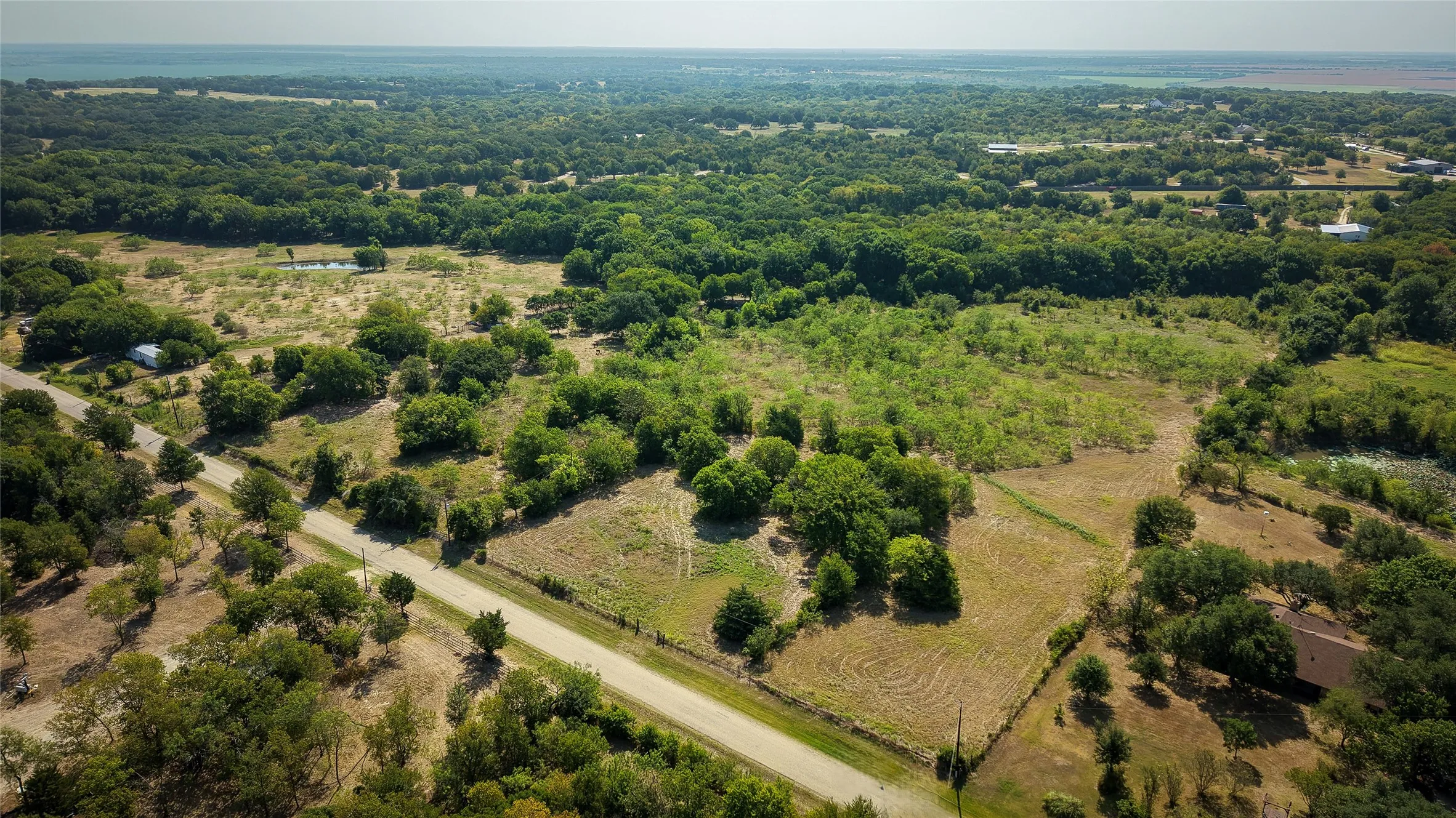 Expansive rural landscape featuring a mix of mature trees and open fields