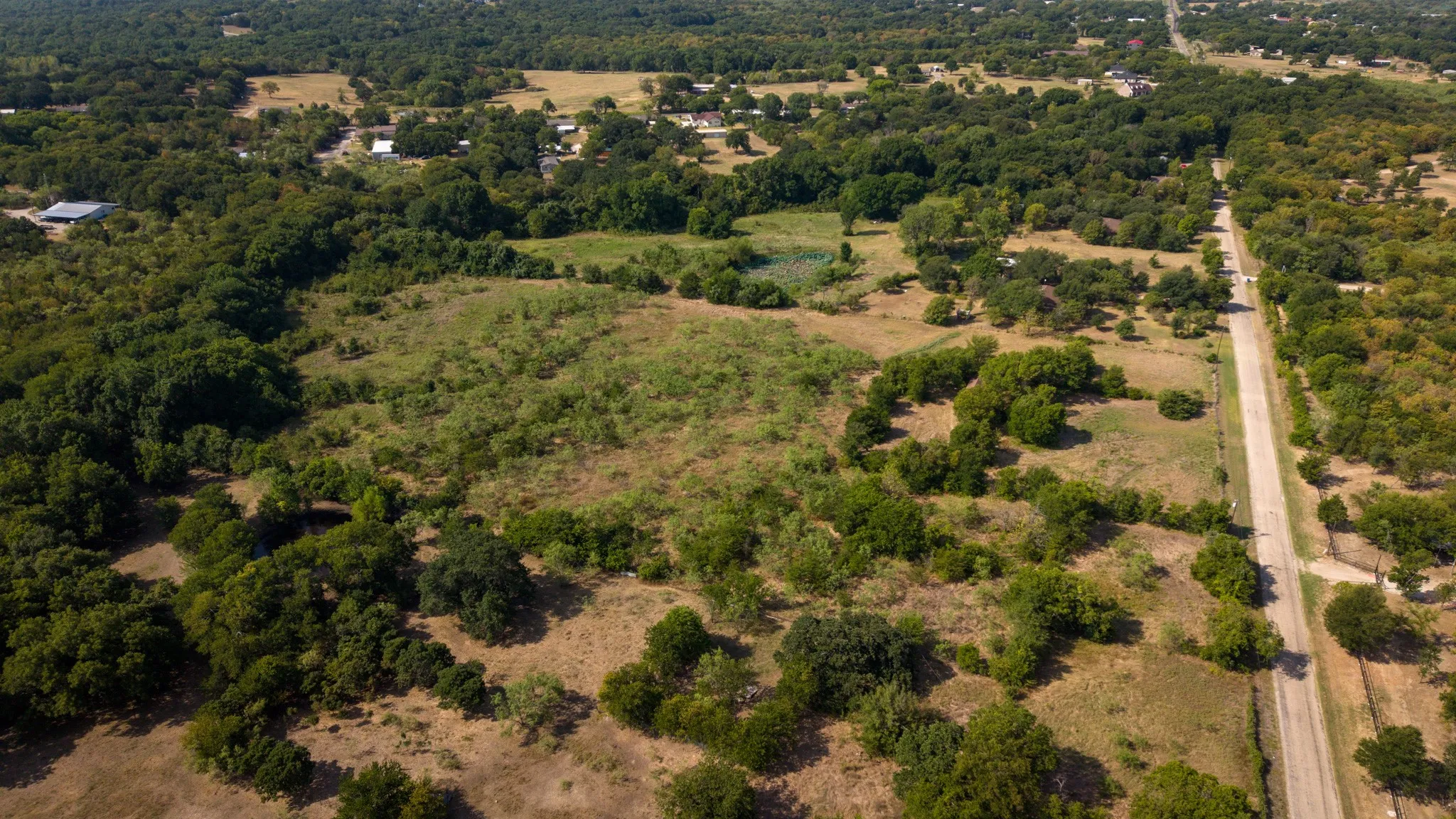 Expansive land parcel featuring a mix of mature trees and open fields