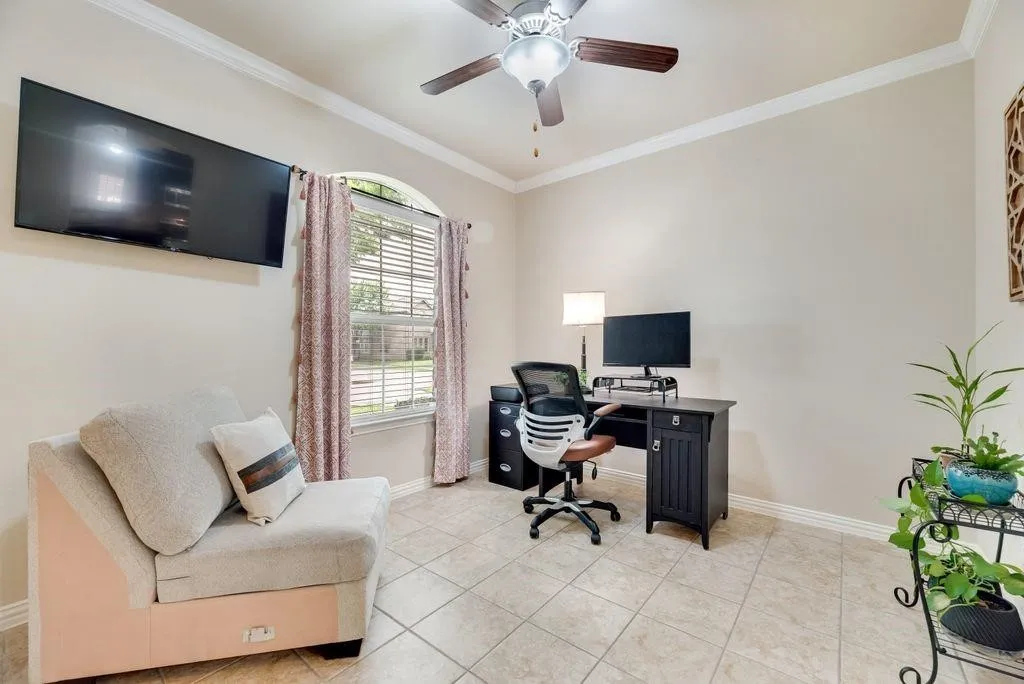 Office area with plenty of natural light, crown molding, light tile patterned floors, and a ceiling fan