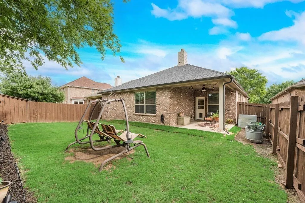 Rear view of house with a ceiling fan, brick siding, a chimney, a patio area, and a fenced backyard