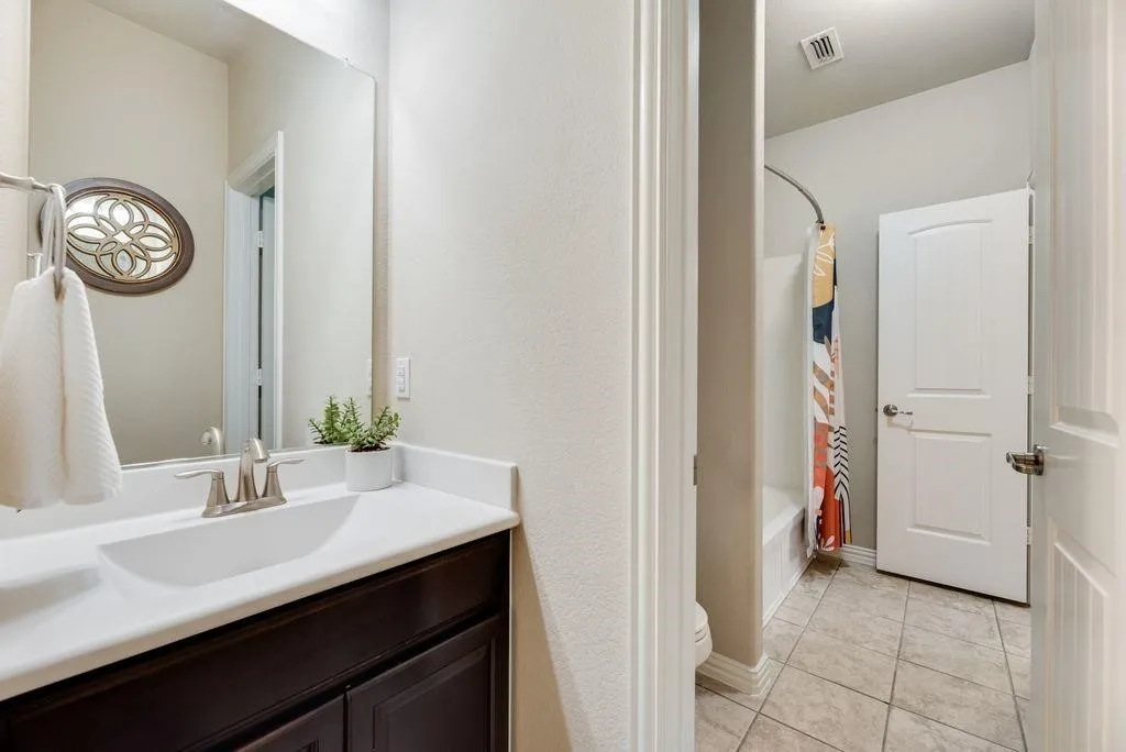 Bathroom with vanity, tile patterned floors, and shower / bath combo with shower curtain
