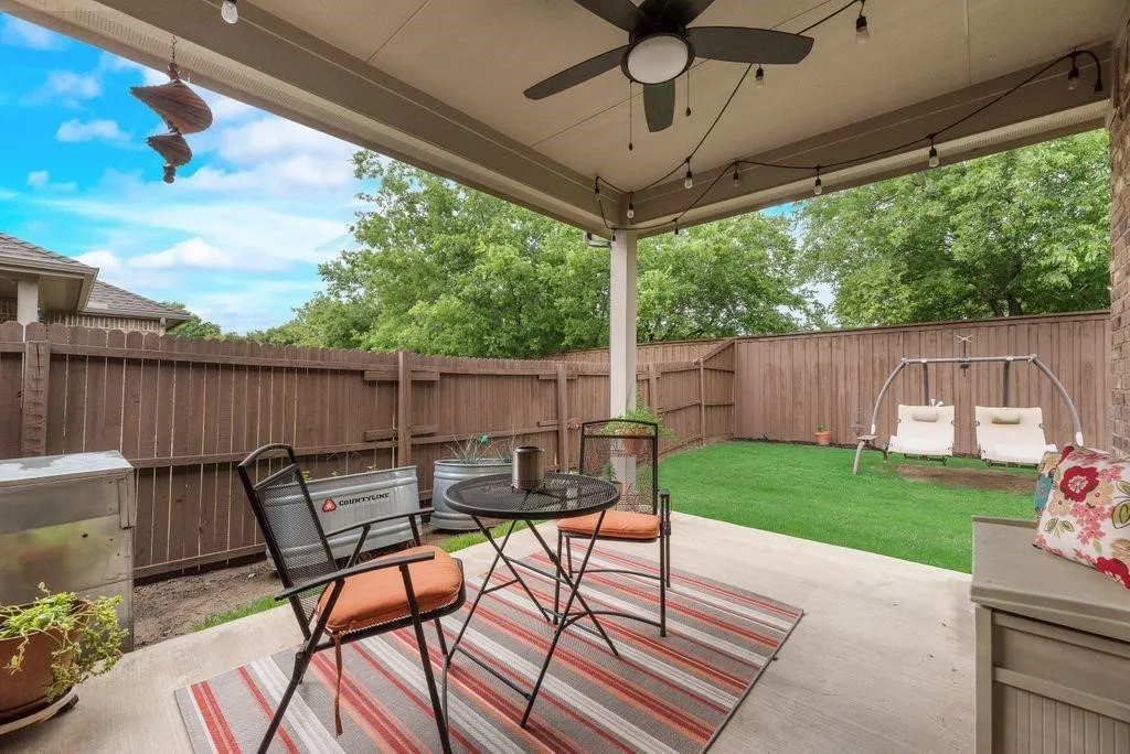 Fenced backyard featuring ceiling fan, a patio area, and outdoor dining area