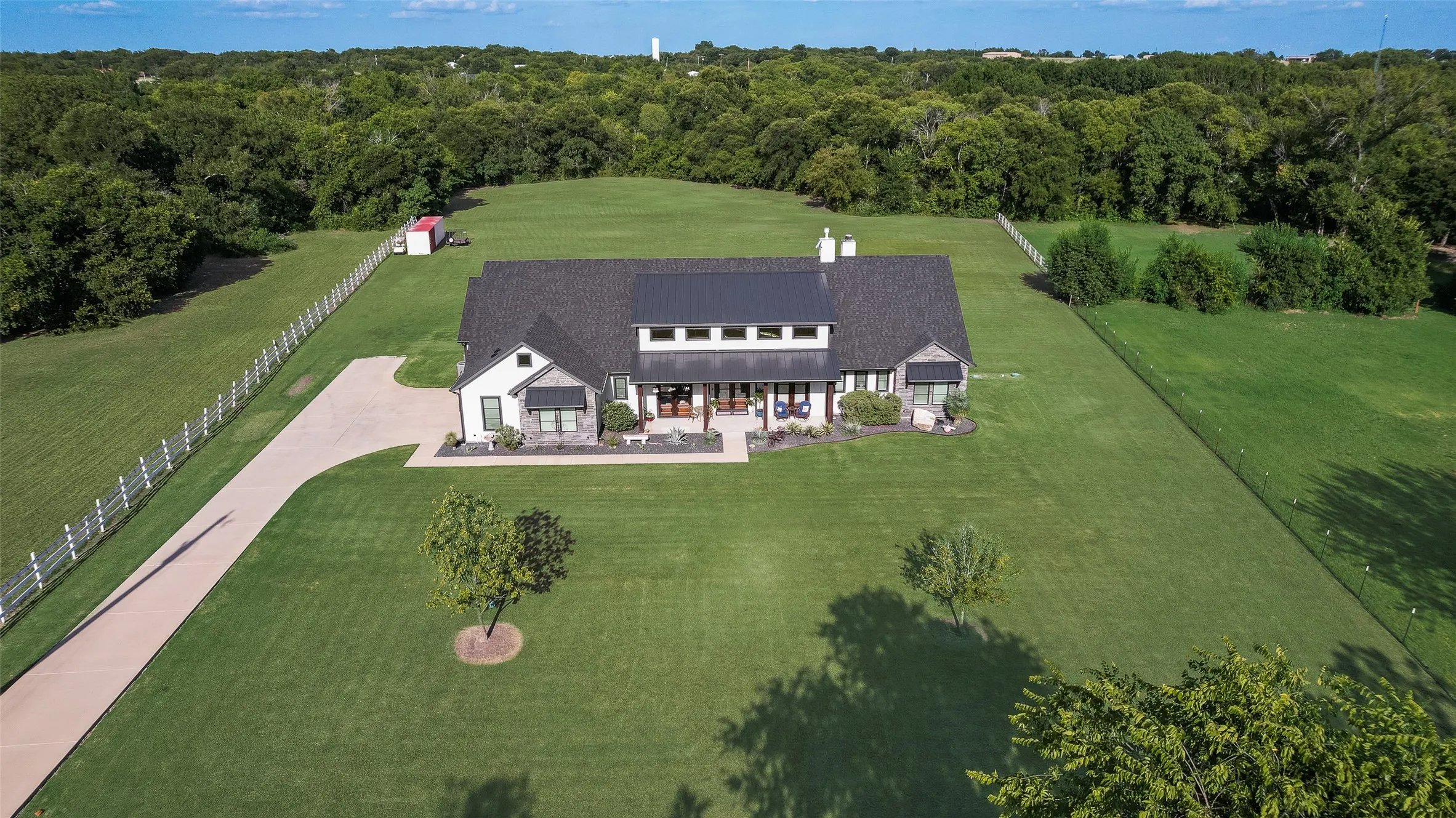 Contemporary farmhouse exterior with a dark shingle roof and a metal roof accent