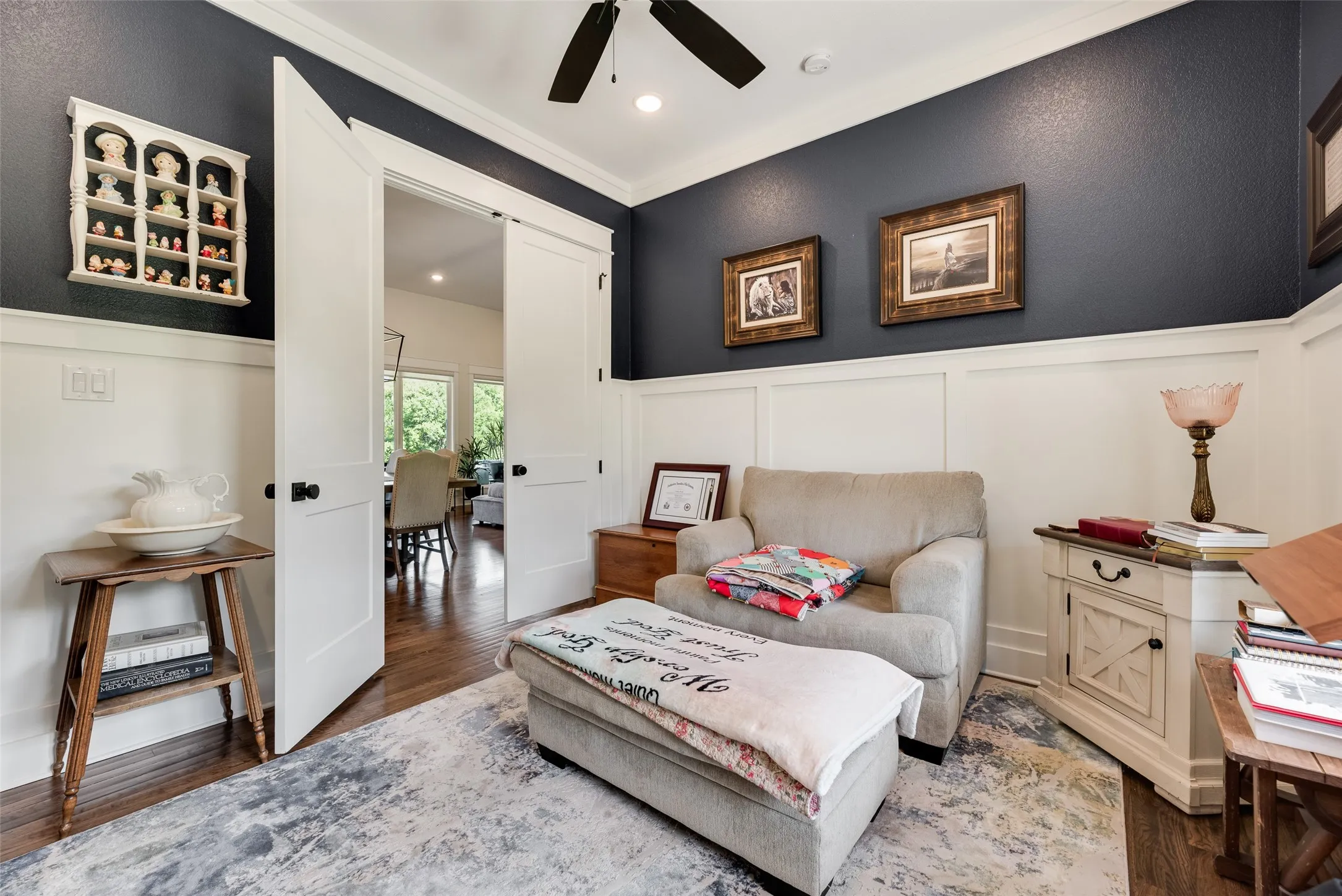 Room featuring dark accent walls, white wainscoting, and wood-finish flooring