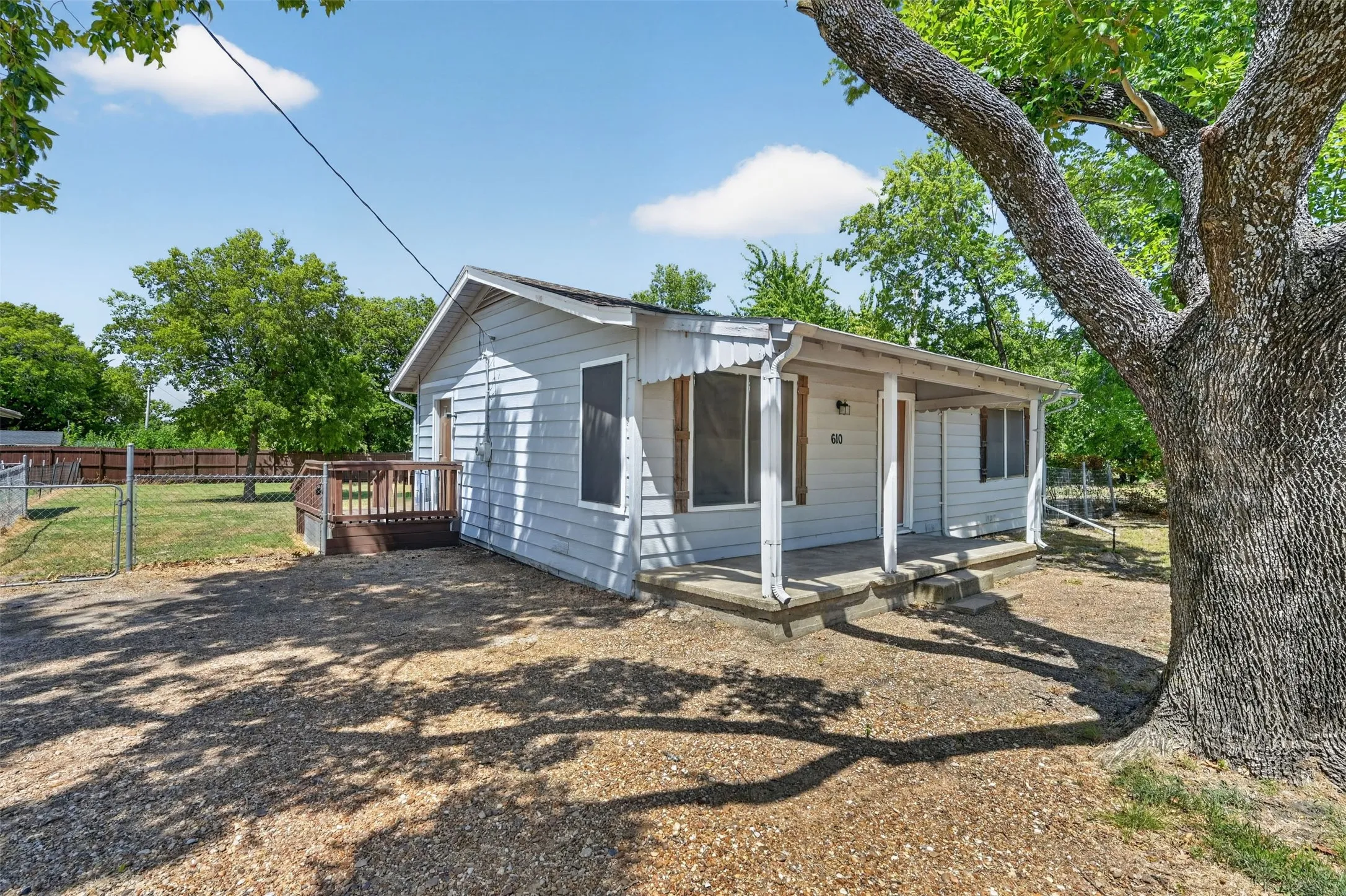 Light blue siding exterior with a covered front porch featuring white columns and concrete steps
