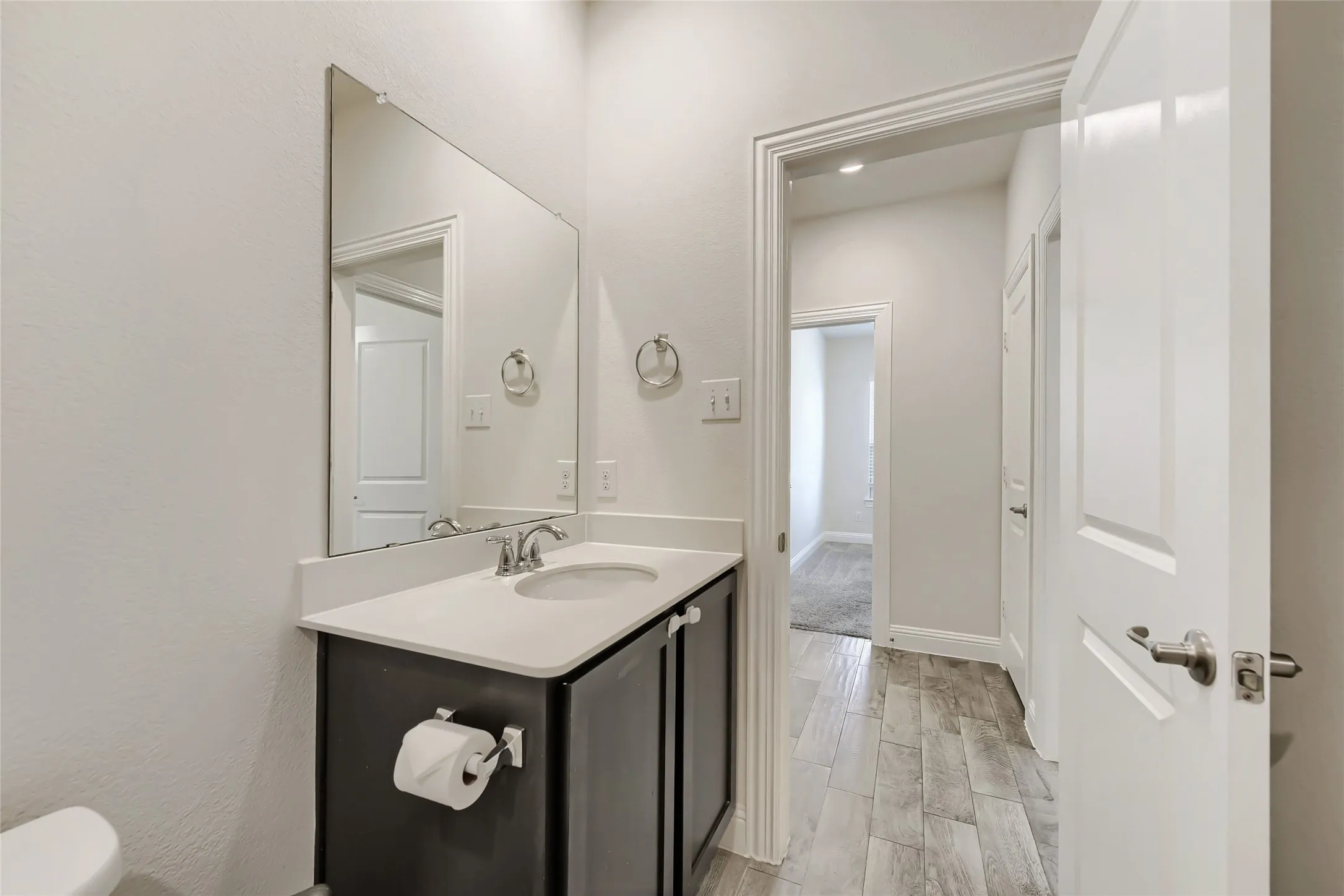 Bathroom vanity featuring a light-toned countertop, undermount sink, and chrome fixtures