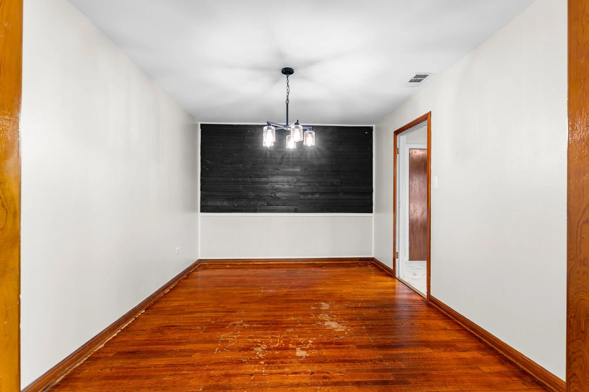 Dining Area with original hardwood floors & accent wall