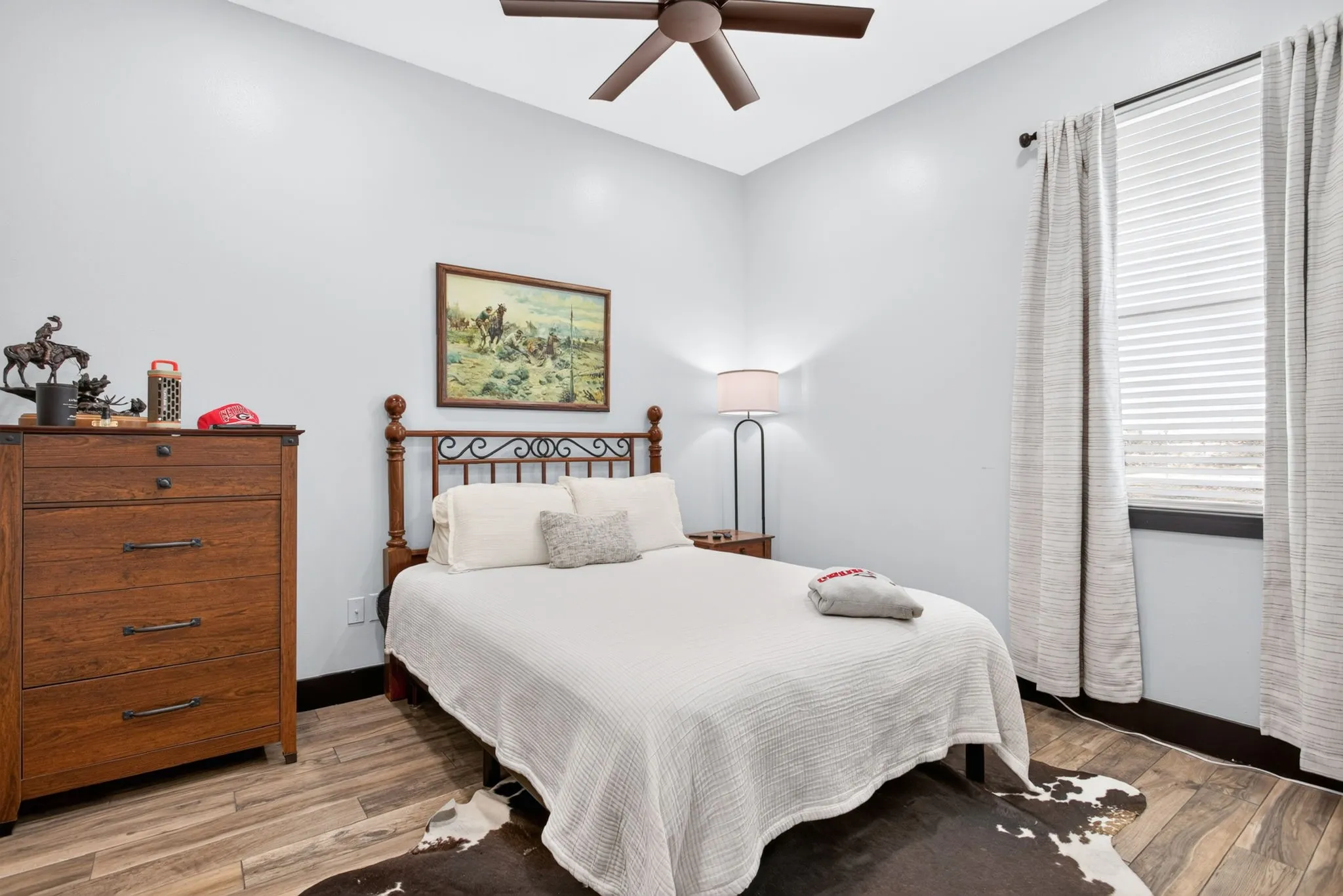 Bedroom featuring wood-finish flooring, a ceiling fan, and high ceilings