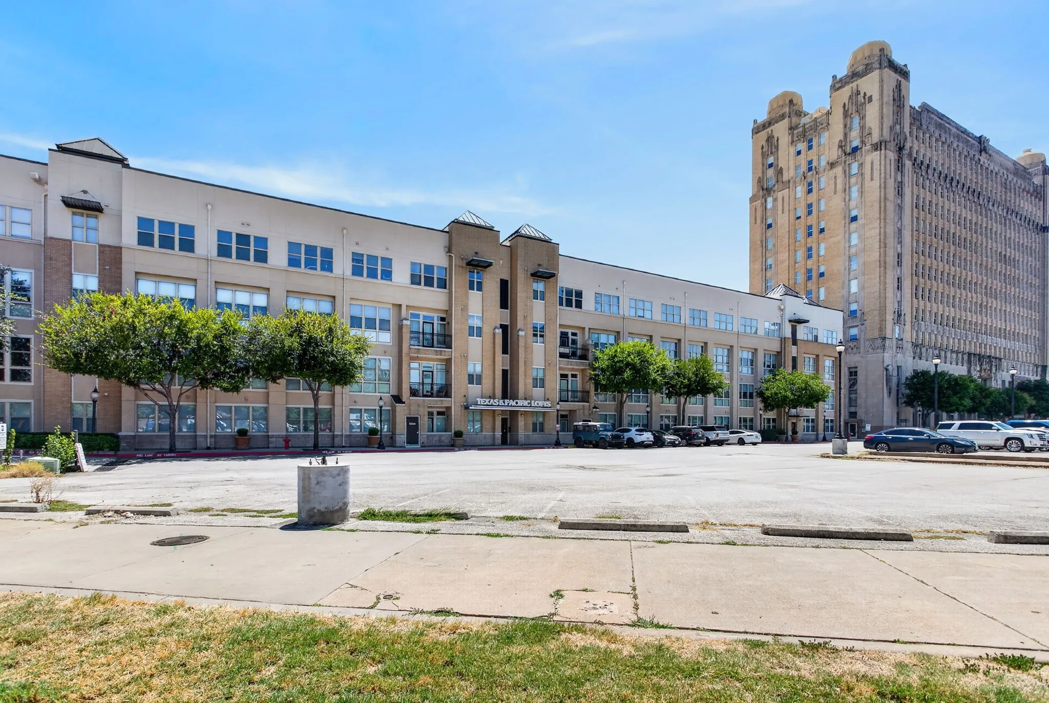 Modern multi-story building featuring a beige and tan facade, multiple windows, and balconies