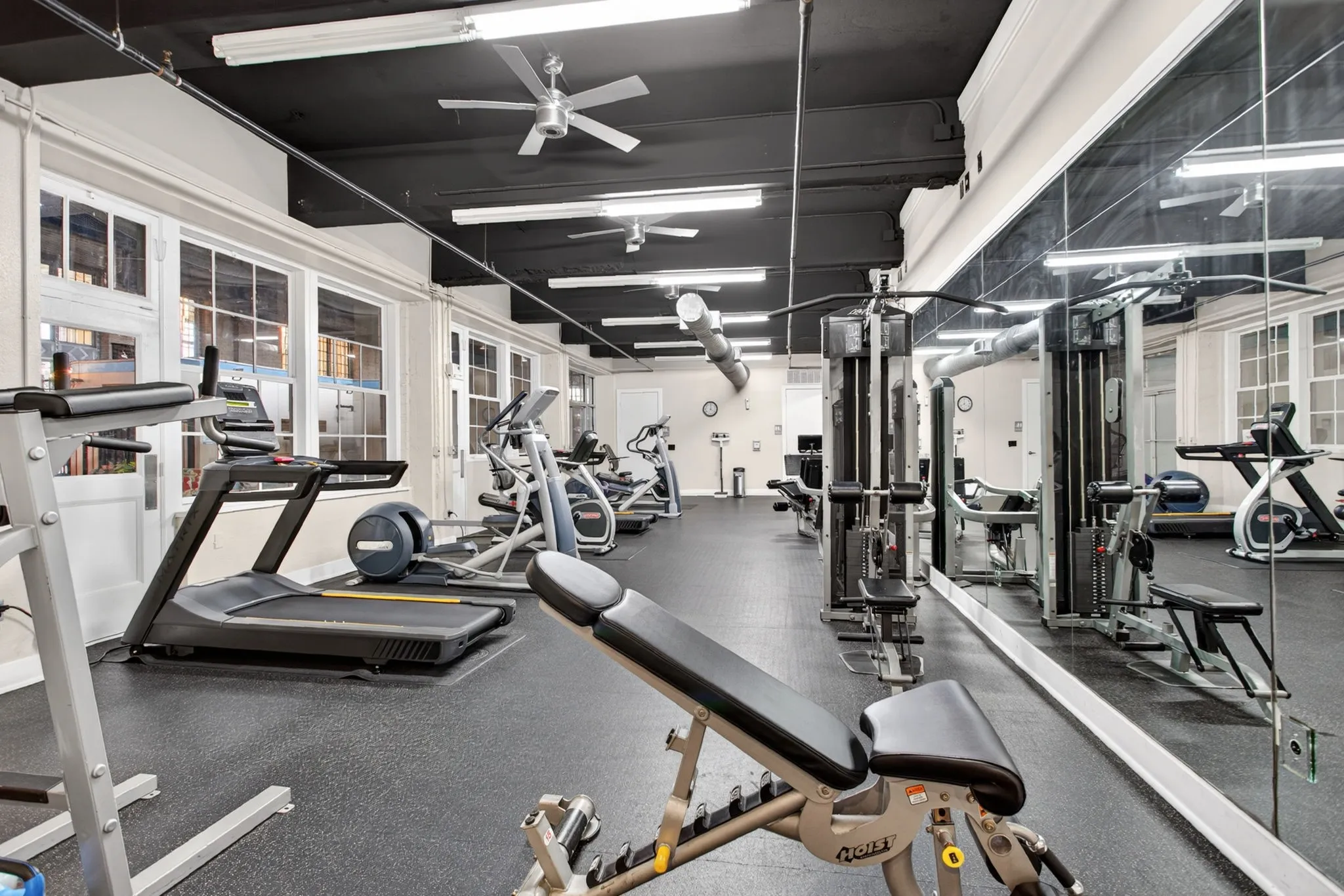 Dedicated fitness center featuring rubber flooring and mirrored walls