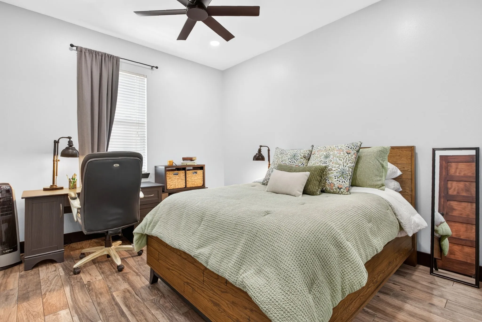 Bedroom featuring wood-finish flooring, a ceiling fan, and a window with blinds