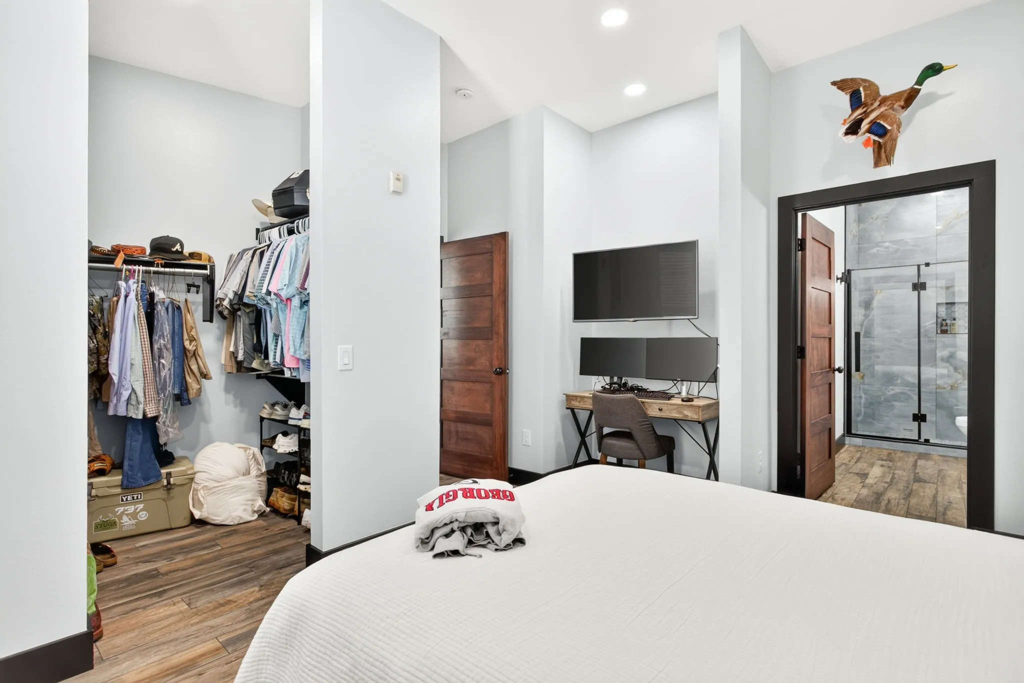 Bedroom featuring wood-finish flooring, recessed lighting, and a built-in open closet system