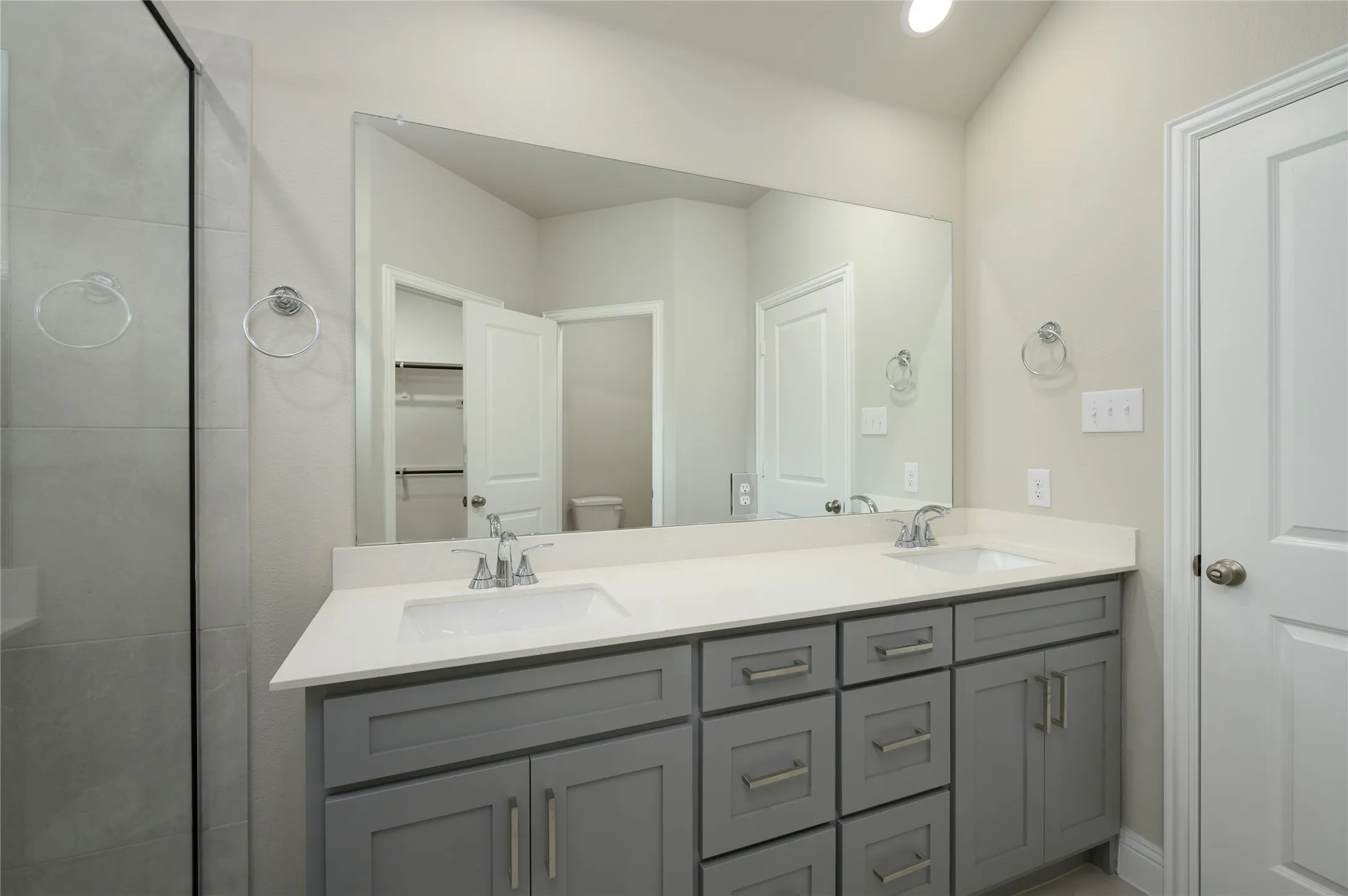 Bathroom with double vanity, toilet, a closet, and a sink